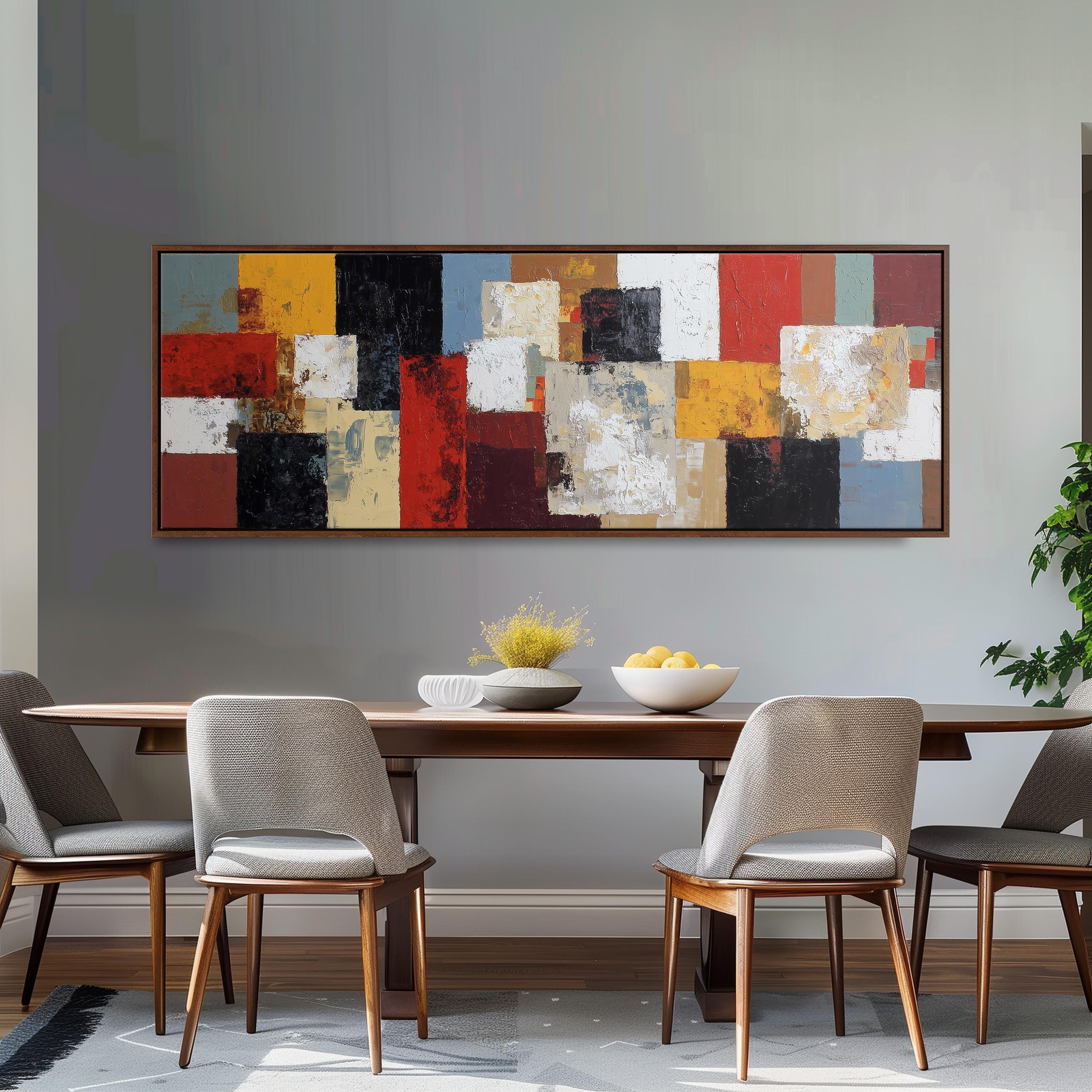 a modern dining room with a large abstract painting hanging on the wall above a wooden dining table. The table is set with a bowl of fruit and a vase of flowers, creating a welcoming and stylish atmosphere.