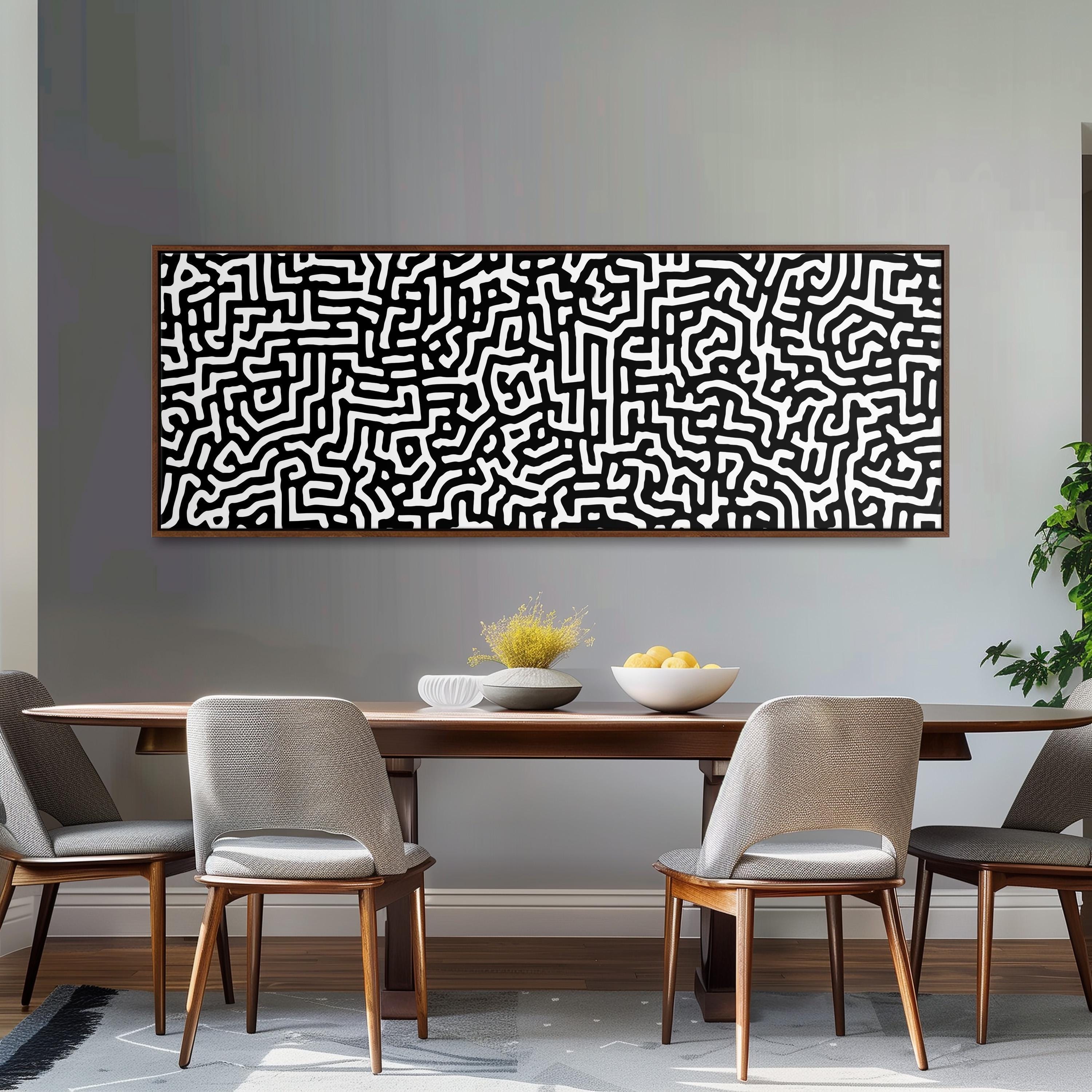 a modern dining room with a wooden table and four chairs. Above the table, there is a large abstract painting with a black and white pattern. On the table, there is a bowl of fruit and a vase of flowers.