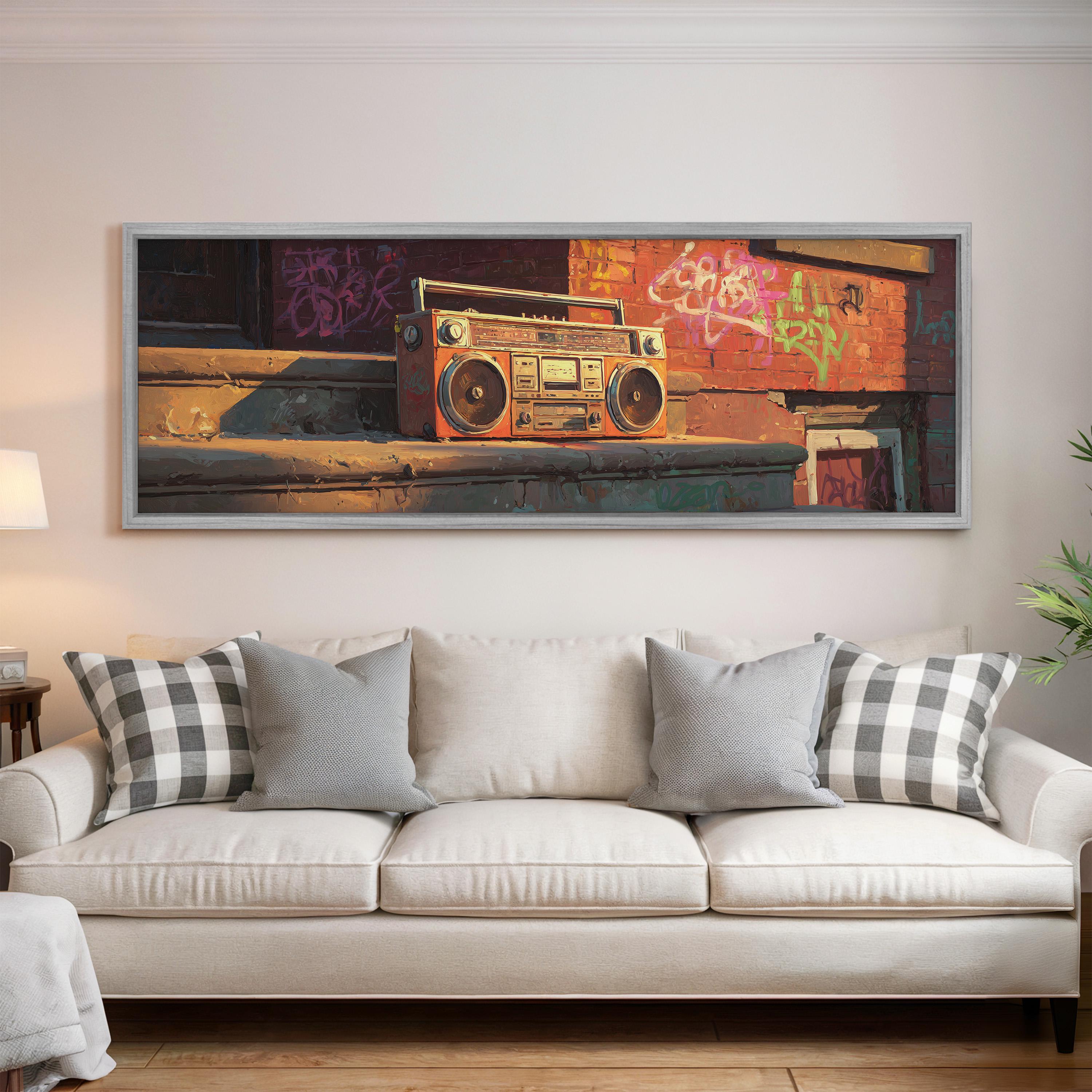 a large framed painting of a vintage boombox on a wall above a white couch with patterned throw pillows.