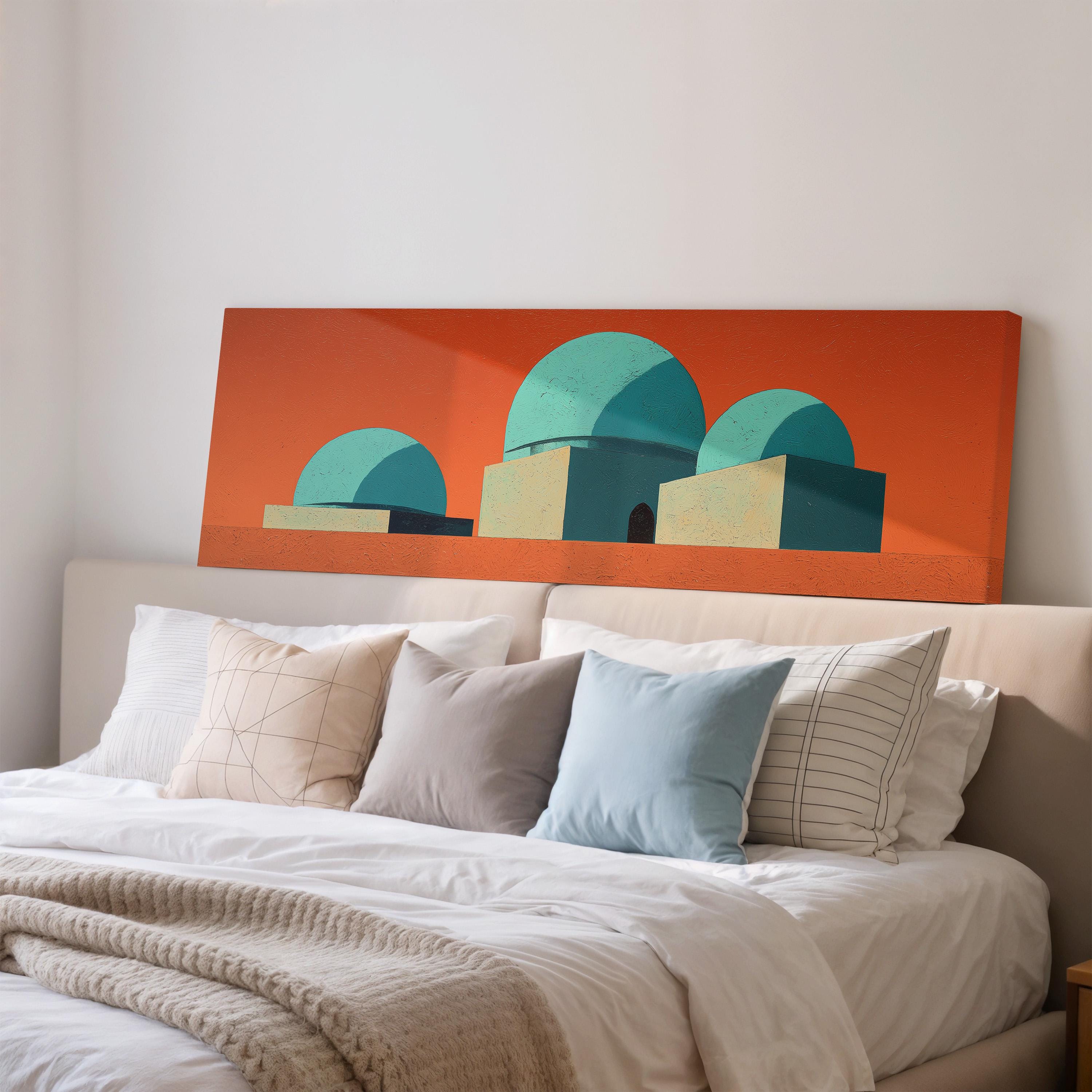 a large orange canvas with a geometric design of three domes on top of a bed with white pillows and a gray blanket.