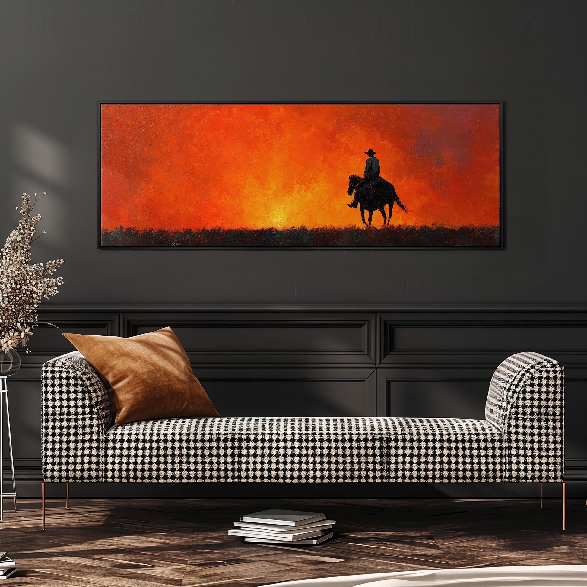 a large painting of a cowboy riding a horse against a backdrop of a sunset. The painting is displayed on a wall above a black and white checkered sofa, which is positioned in front of a bookshelf.