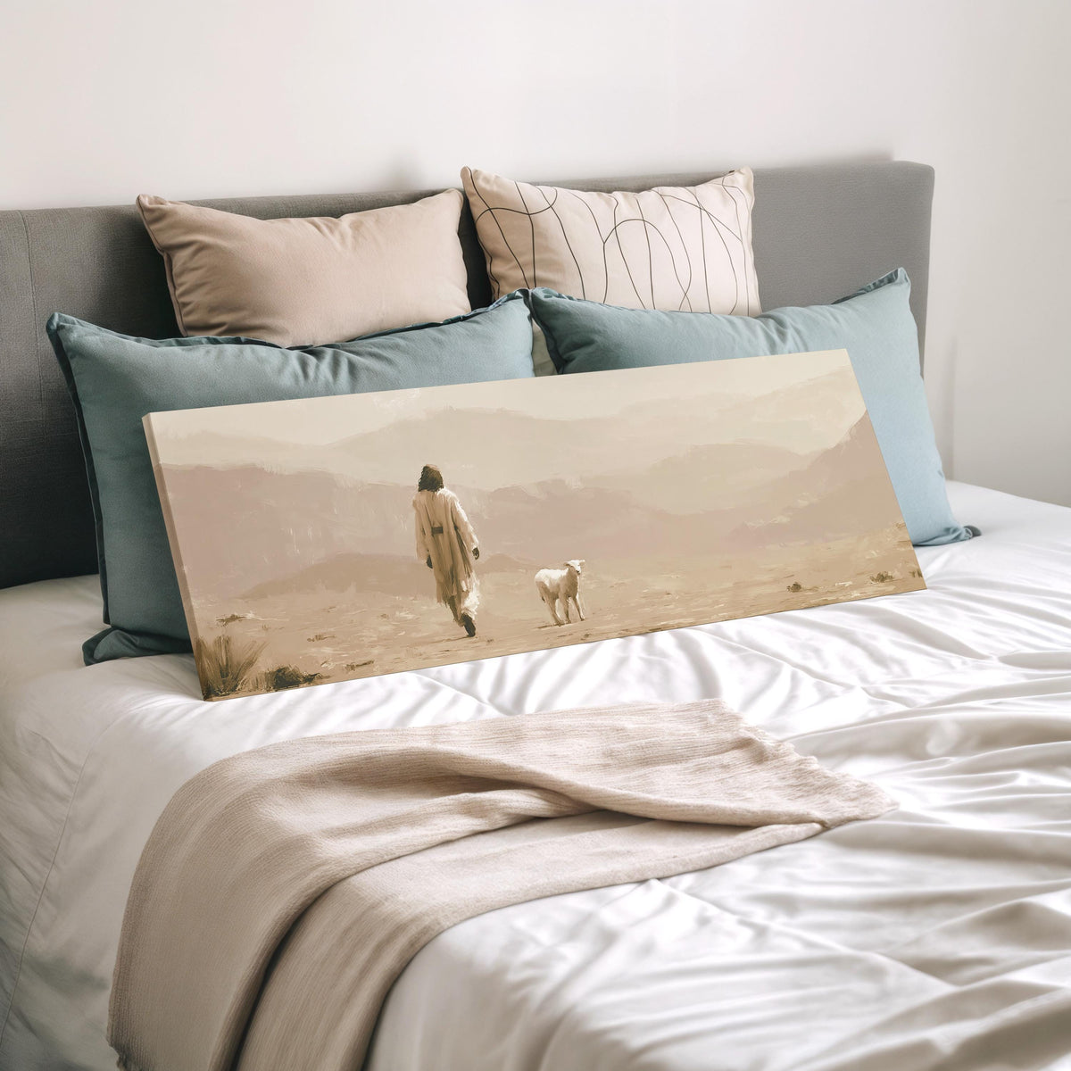 Jesus walking with a lamb through the desert wide panoramic canvas print laid on a bed to show its size
