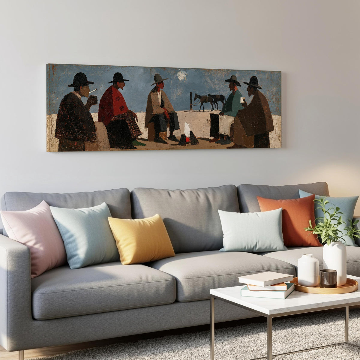 Cowboys gathered around a campfire panoramic canvas print above a grey sofa in a living room