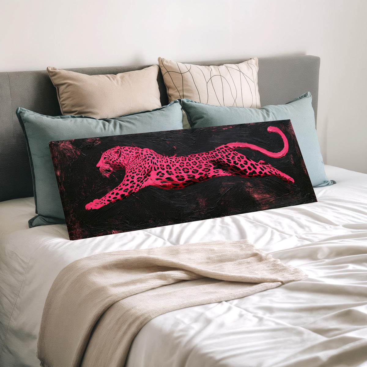 Pink leaping leopard wide panoramic canvas print laid on a bed to show its size