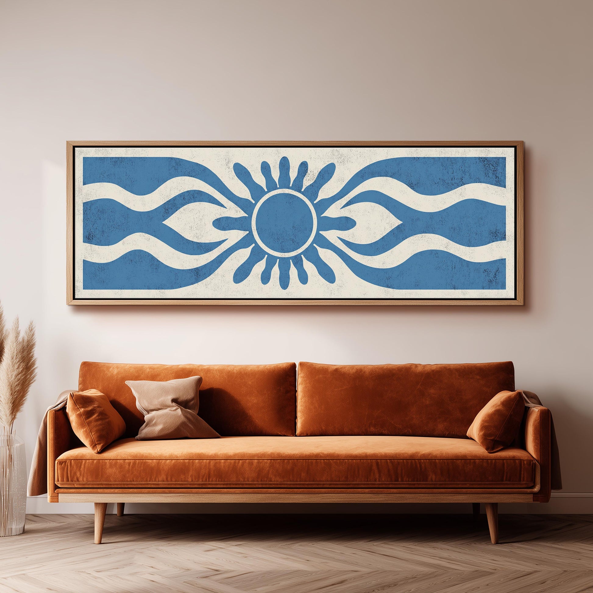 a large, rectangular, framed artwork hanging on a wall above a brown sofa.