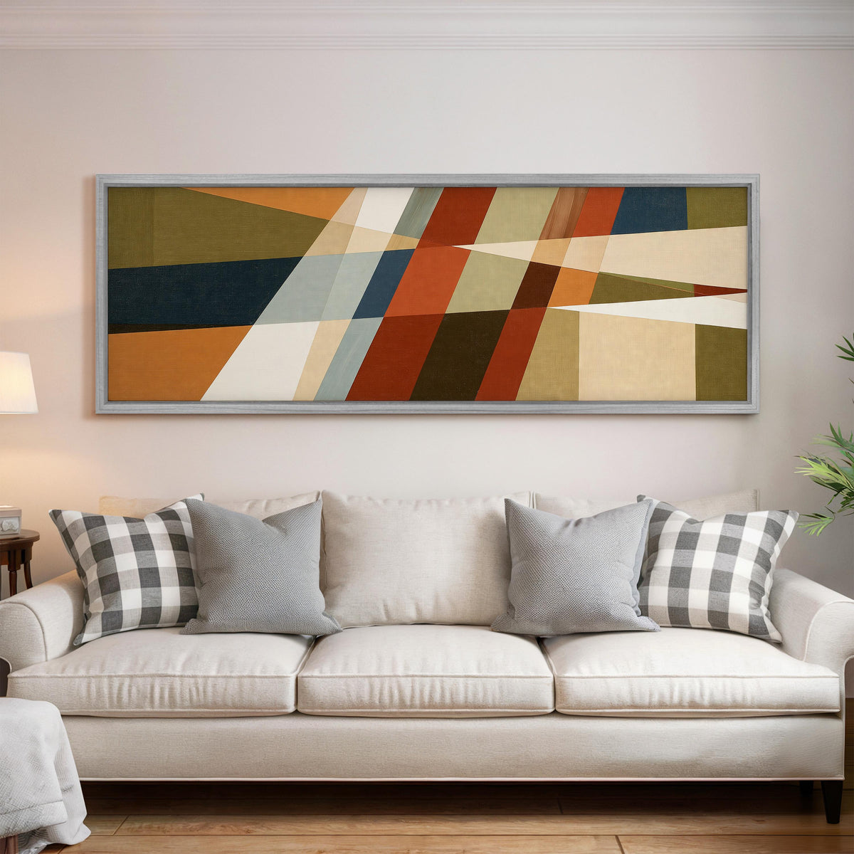Rust and navy diagonal color blocks panoramic canvas print above a white sofa in a bright living room