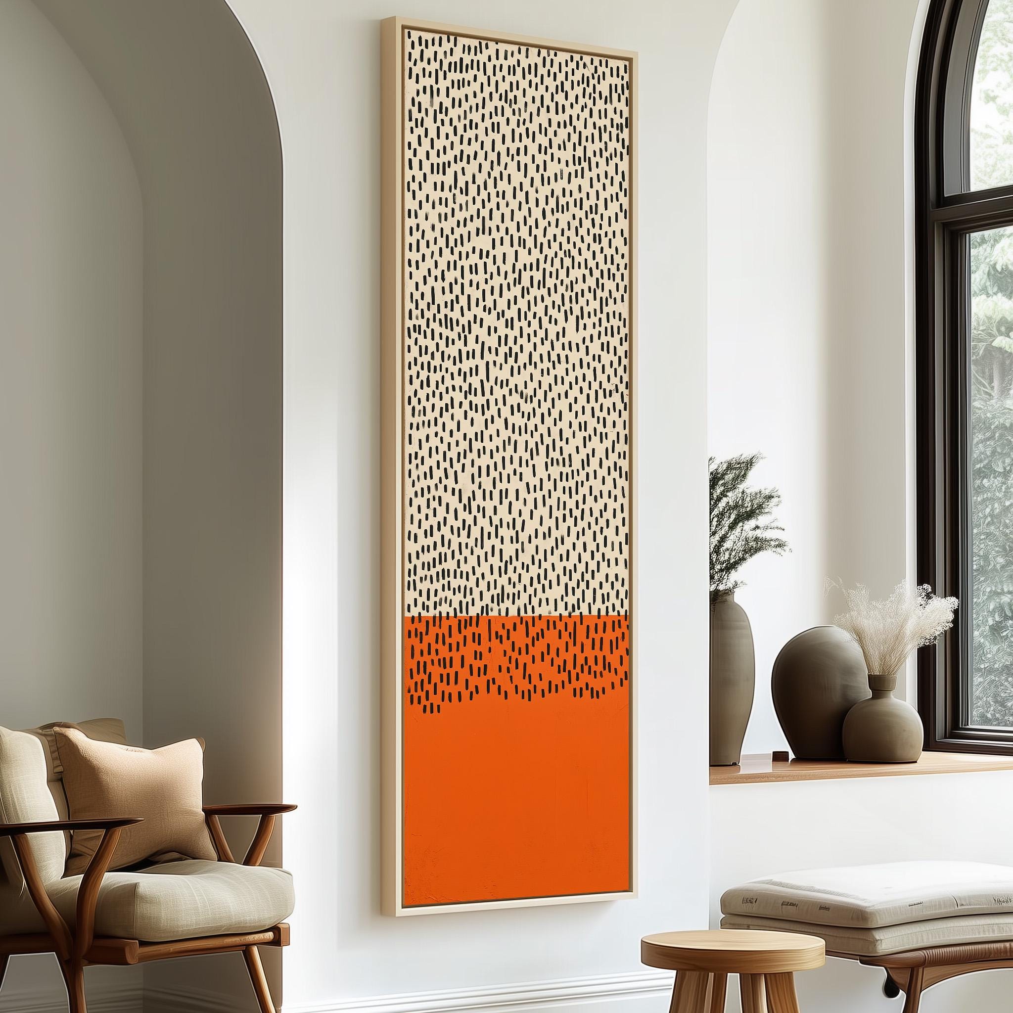 a modern living room with a large abstract painting hanging on the wall, a wooden chair, a small table, and a window with a plant on the sill.