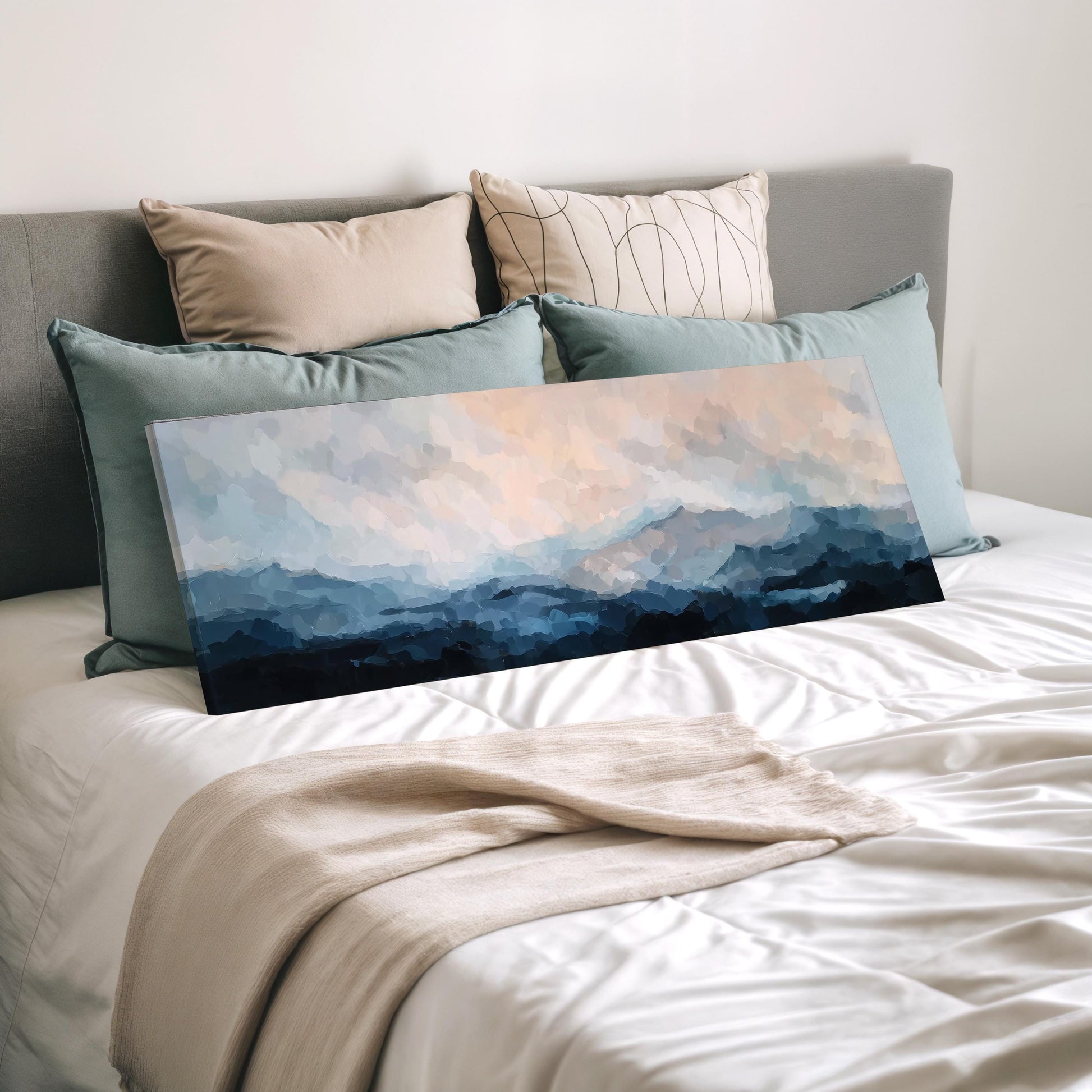 a bedroom with a bed covered in white sheets and a large painting of a landscape on the bed. The painting features a cloudy sky and mountains in shades of blue and gray.