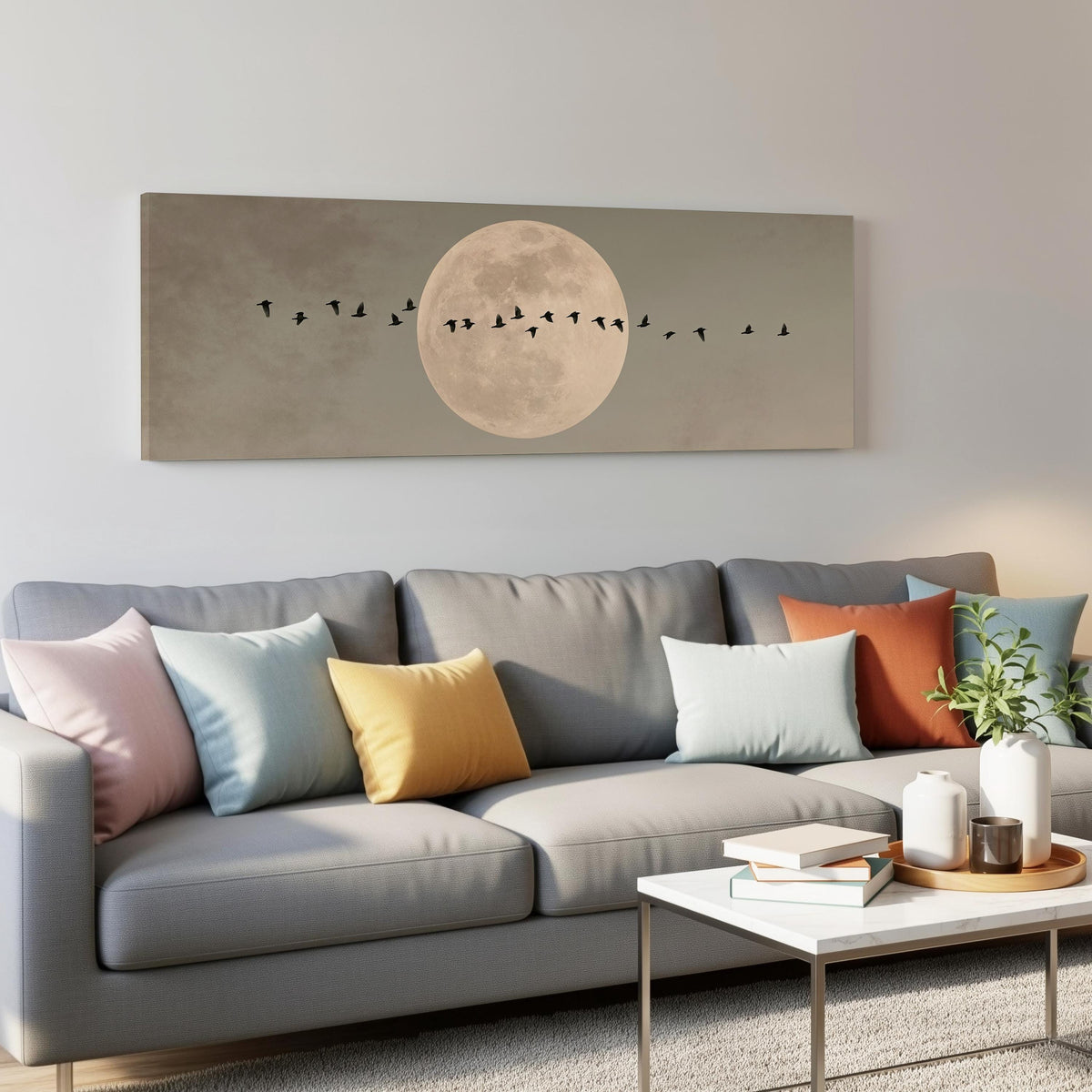 Geese crossing a full moon on grey panoramic canvas print above a grey sofa in a living room