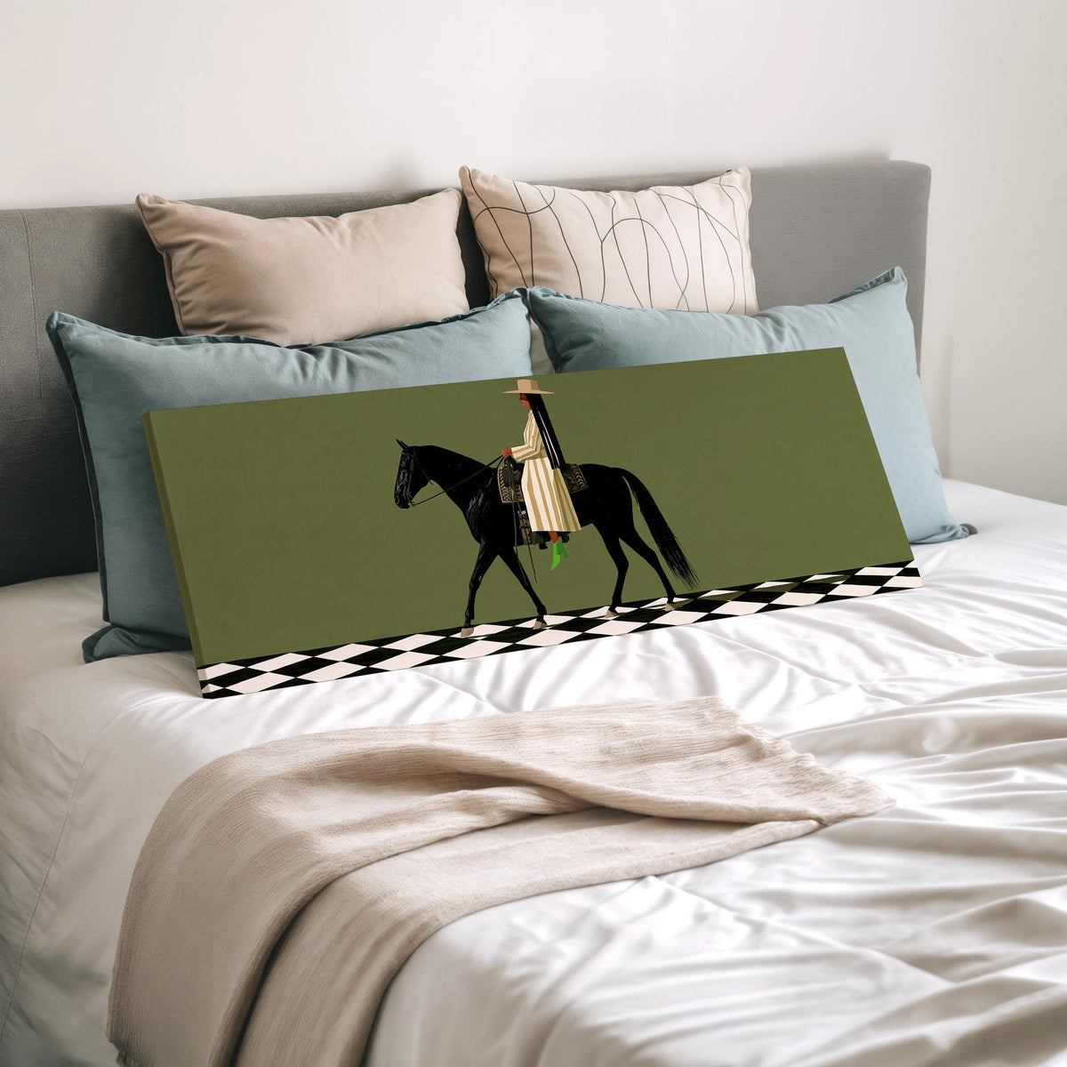 Woman riding a black horse on a checkerboard wide panoramic canvas print laid on a bed to show its size