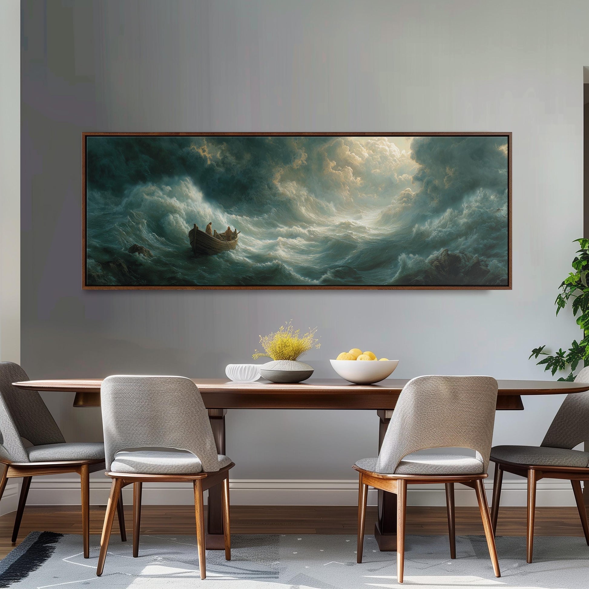 a large painting of a stormy sea hanging on a wall above a wooden dining table with four chairs. The painting depicts a boat sailing through rough waters, with a large wave crashing behind it. The table is set with a bowl of fruit and a vase of flowers, creating a cozy and inviting atmosphere.