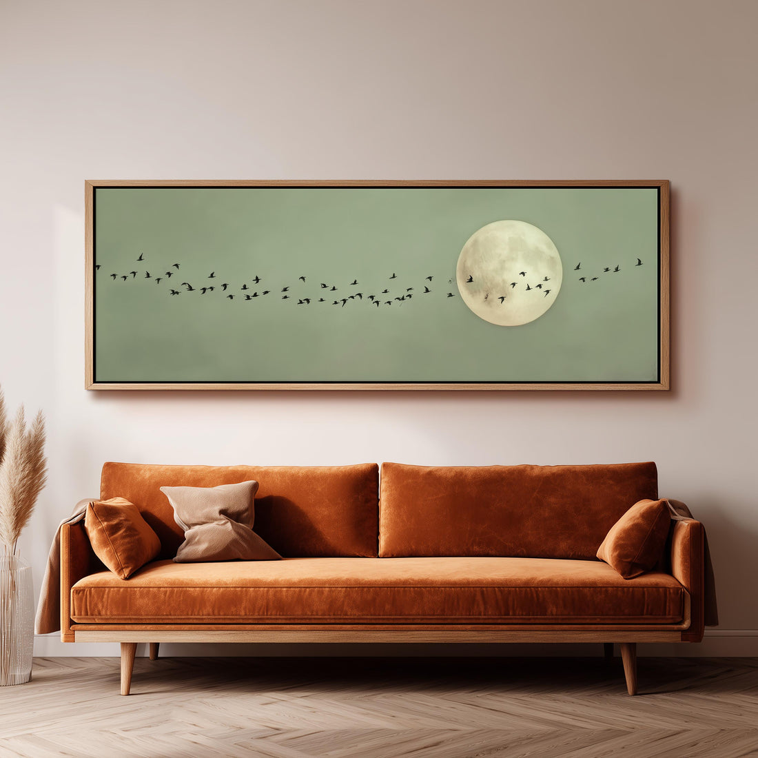a large framed artwork depicting a flock of birds flying in front of a full moon, creating a serene and peaceful atmosphere.