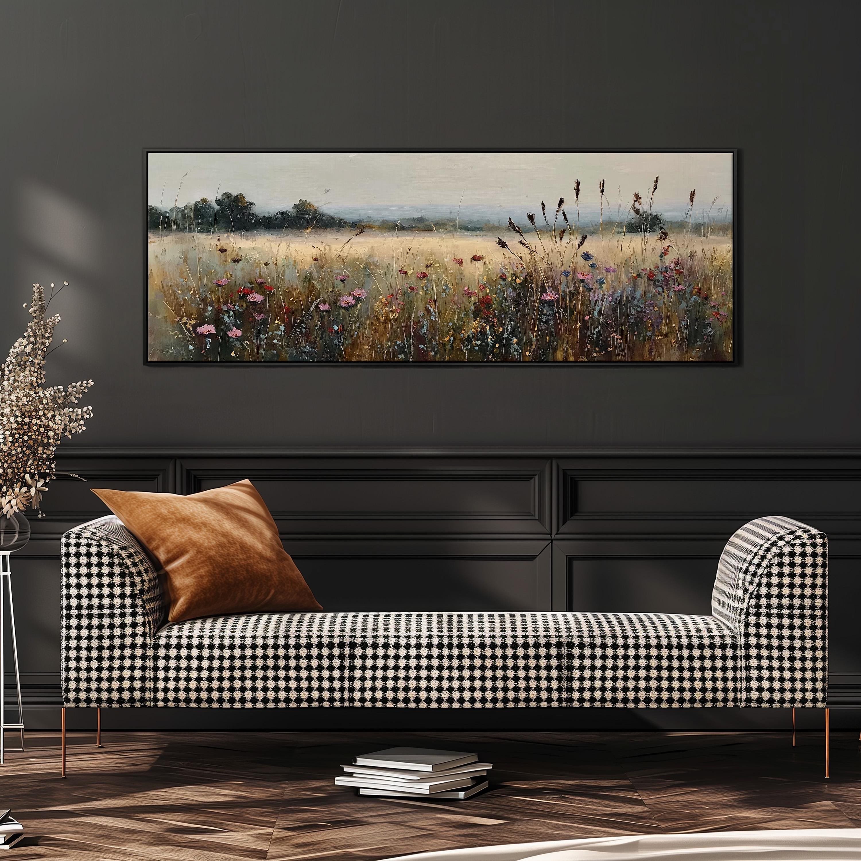 a black and white checkered sofa with a brown throw pillow, set against a dark wall with a large painting of a field of flowers hanging above it.