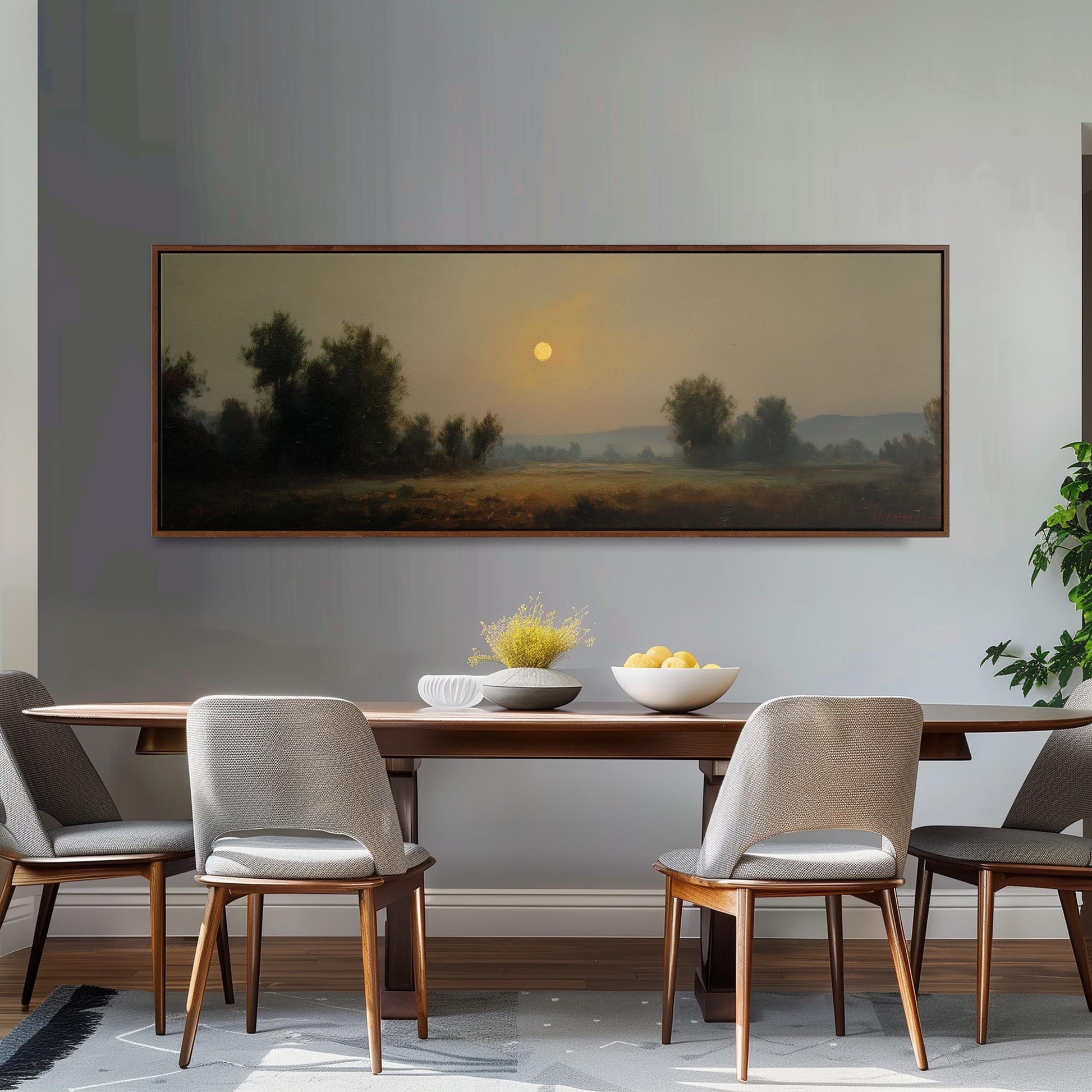 a dining room with a large painting of a landscape hanging on the wall above a wooden dining table with four chairs. The painting depicts a serene countryside scene with a sunlit sky and trees in the distance.