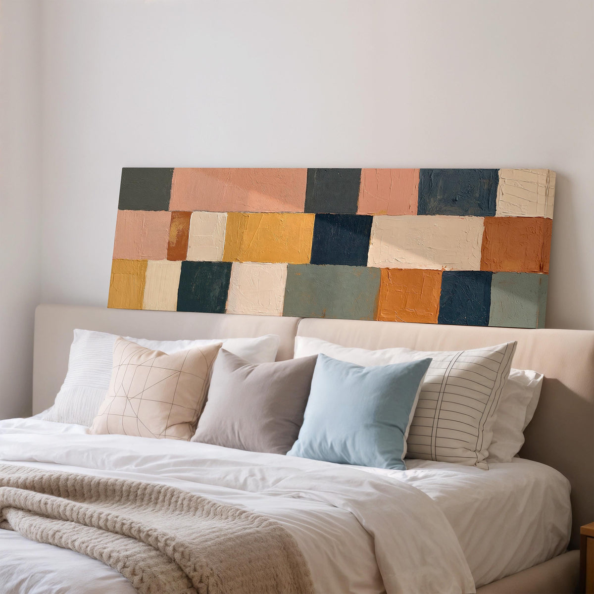 Mustard, sage, blush and navy patchwork wide panoramic canvas print above a bed in a bedroom