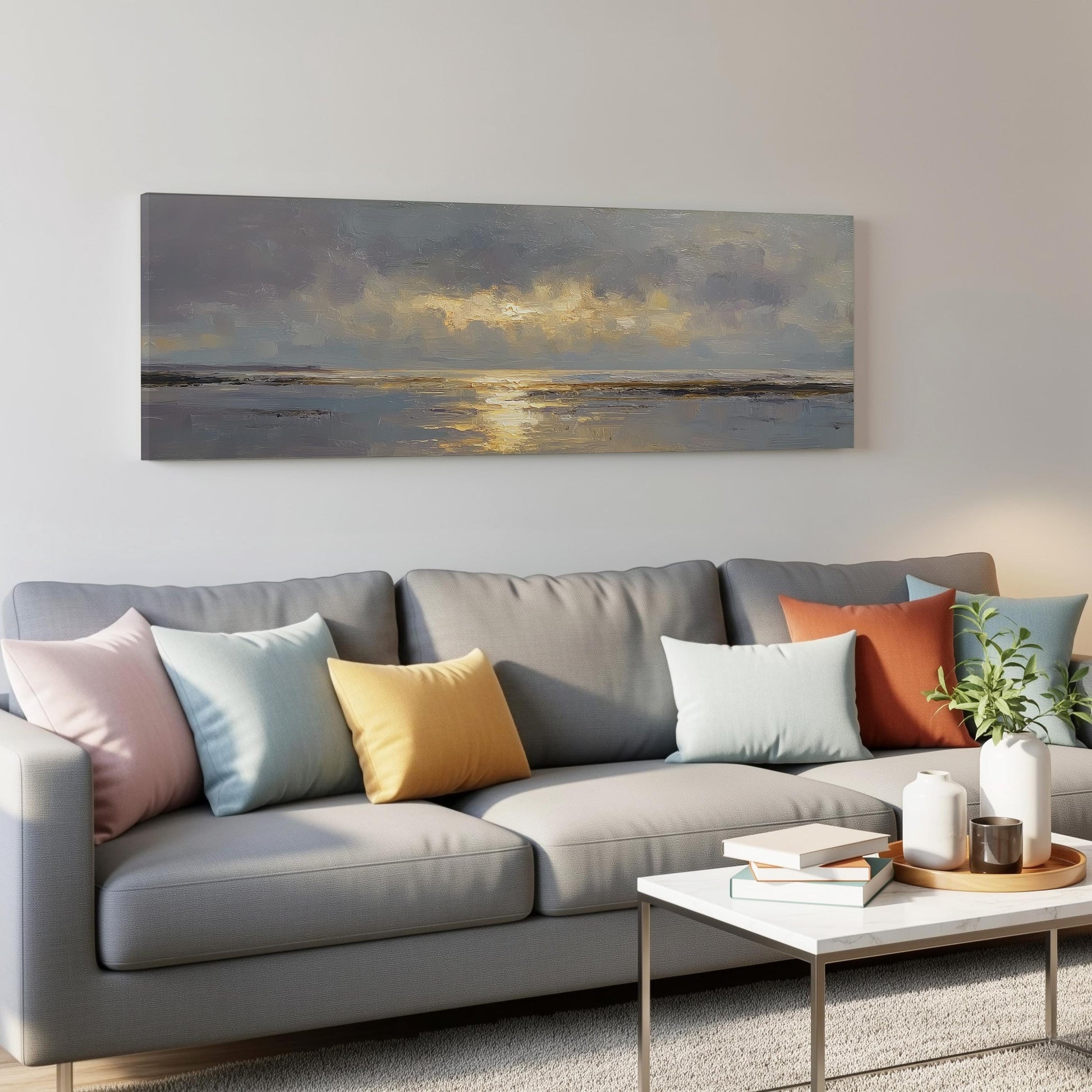 a gray couch with colorful throw pillows, a coffee table, and a painting of a sunset on the wall above it.