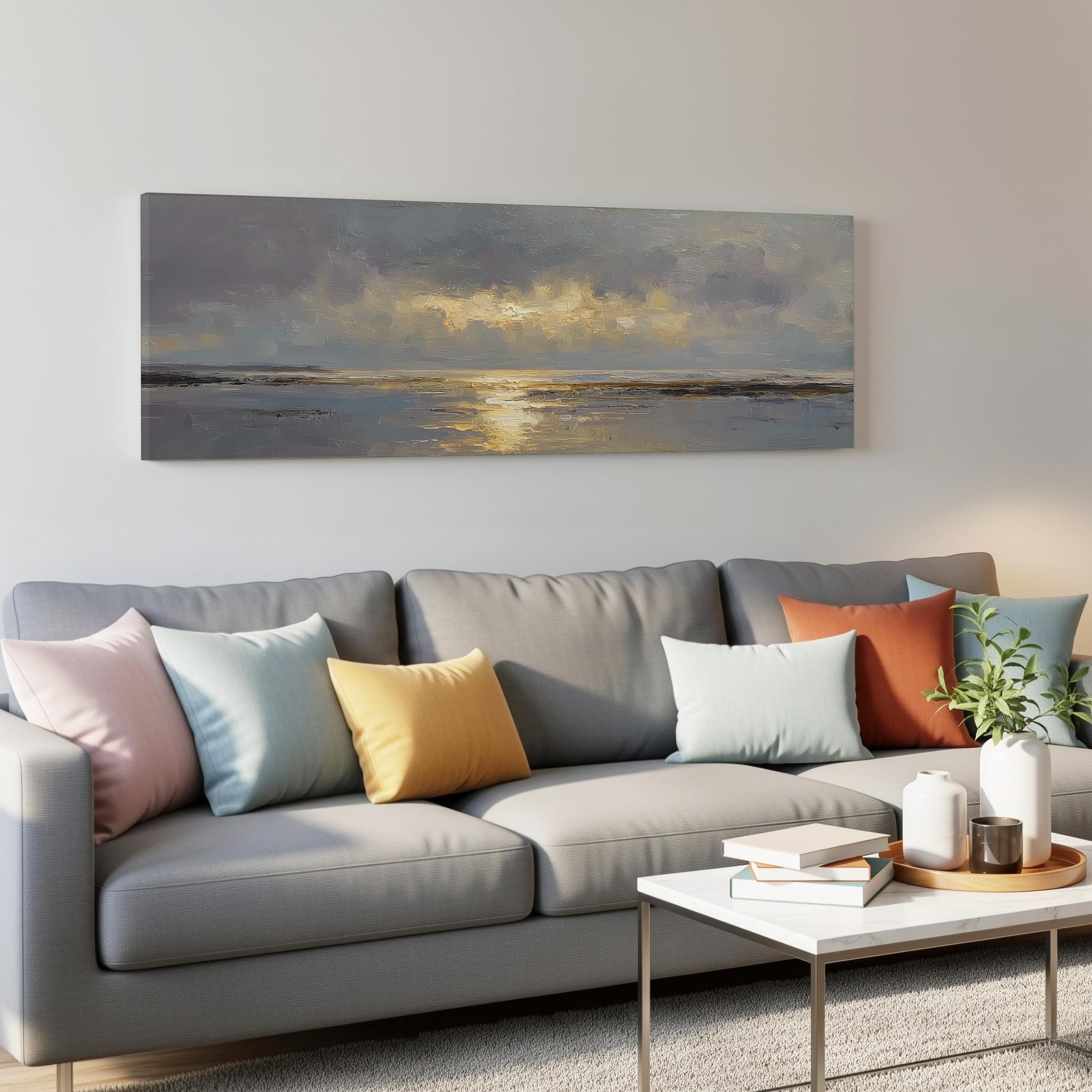 a gray couch with colorful throw pillows, a coffee table, and a painting of a sunset on the wall above it.