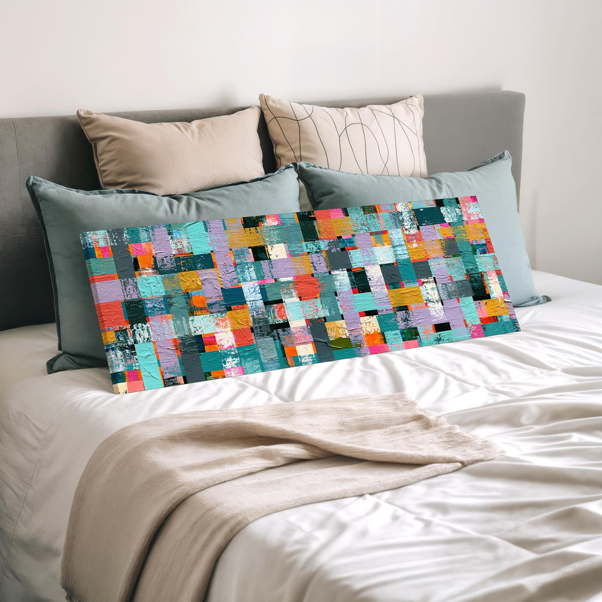 Woven grid of teal and pink blocks wide panoramic canvas print laid on a bed to show its size
