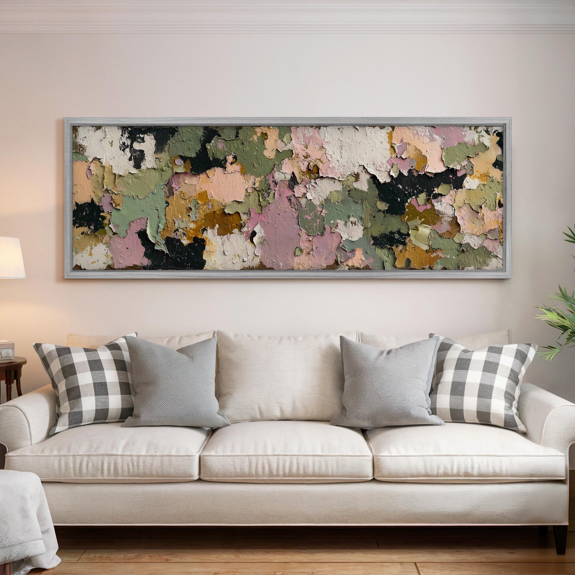 a large, colorful abstract painting hanging on a wall above a white couch with gray and white patterned pillows.
