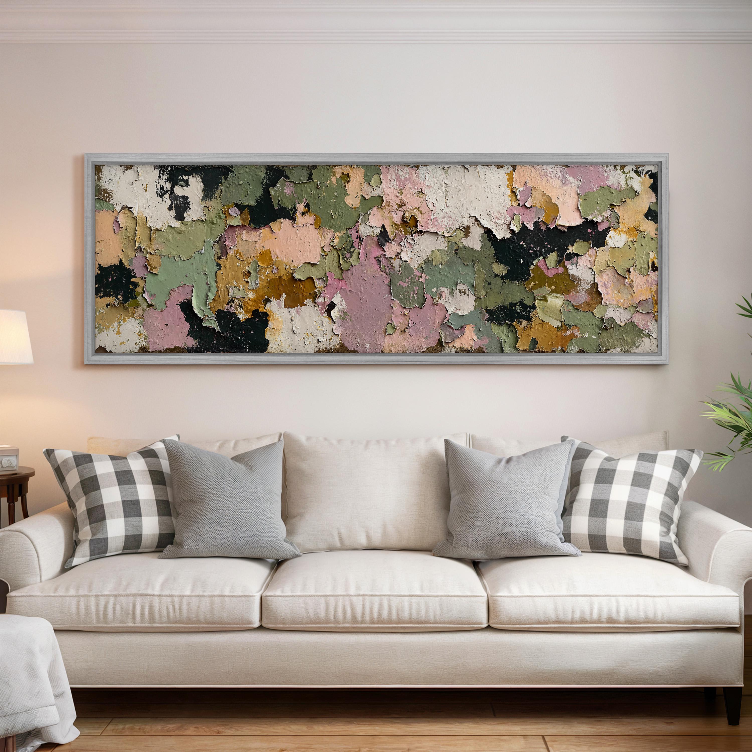 a large, colorful abstract painting hanging on a wall above a white couch with gray and white patterned pillows.