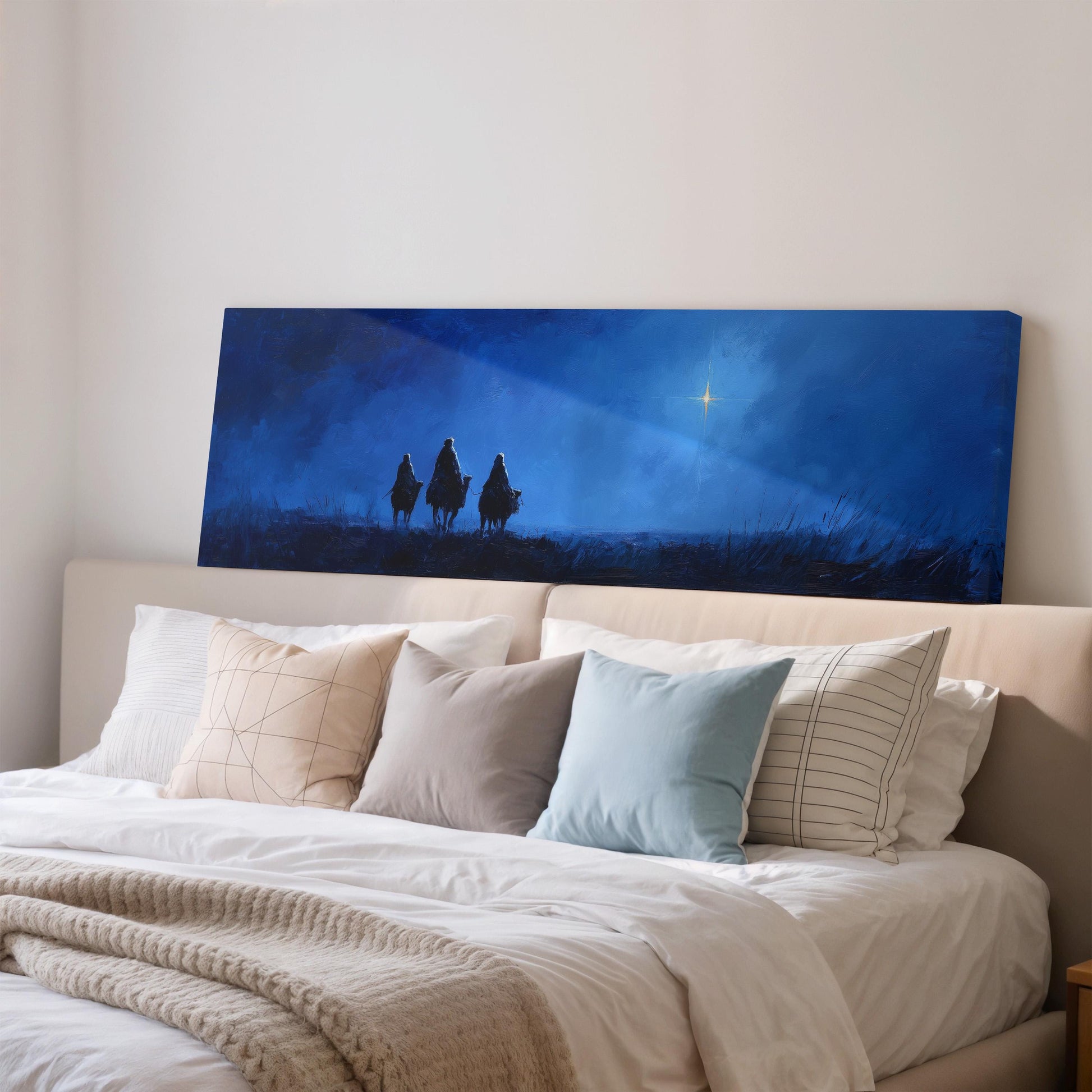 a serene bedroom scene with a large bed adorned with white pillows and a cozy blanket. Above the bed, a large canvas print features silhouettes of three people walking on a grassy hill under a starry night sky.