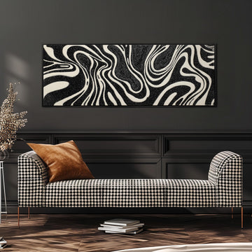a modern living room with a black and white checkered sofa, a stack of books, and a large abstract painting on the wall.