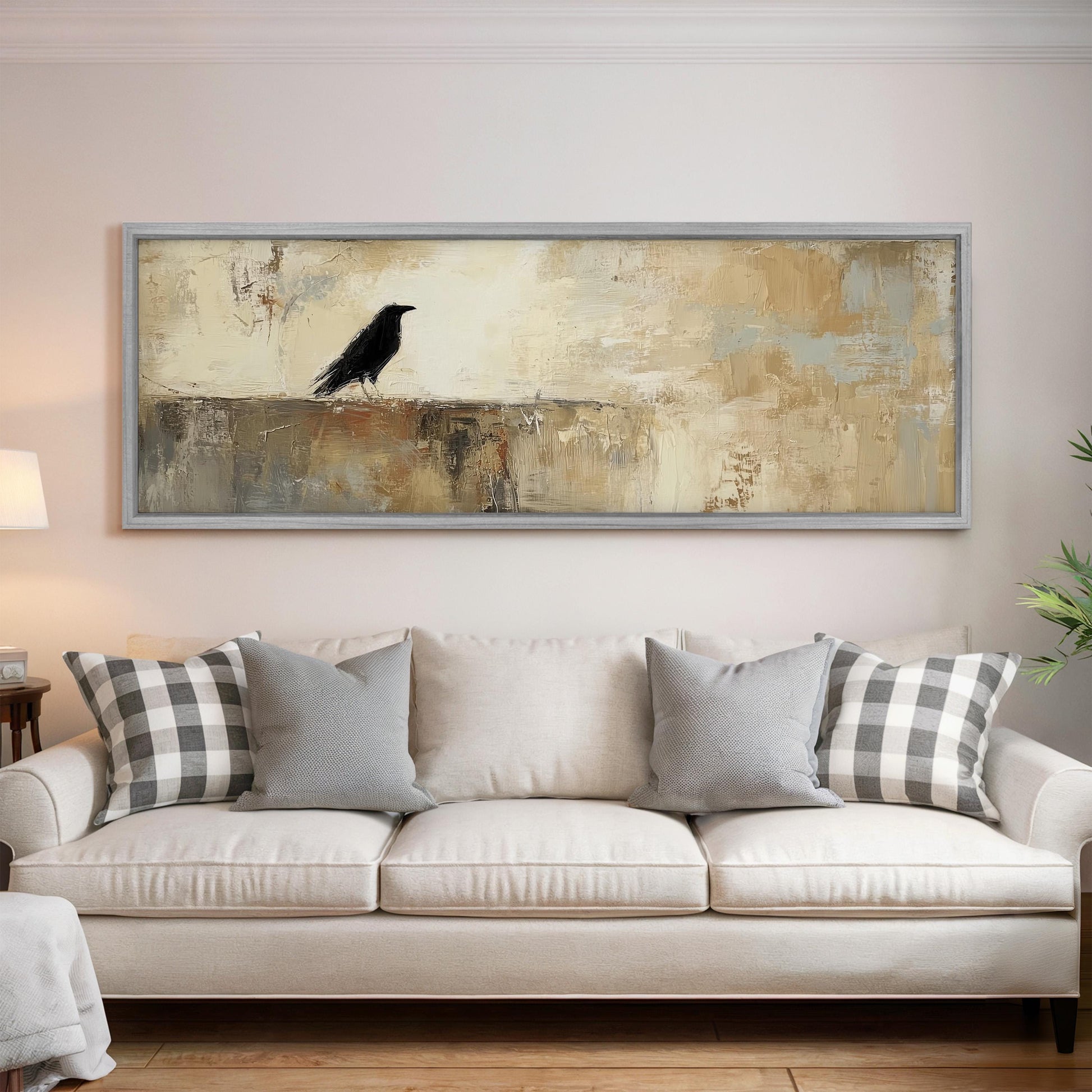 a large painting of a black bird perched on a wall above a white couch with gray and white plaid throw pillows.