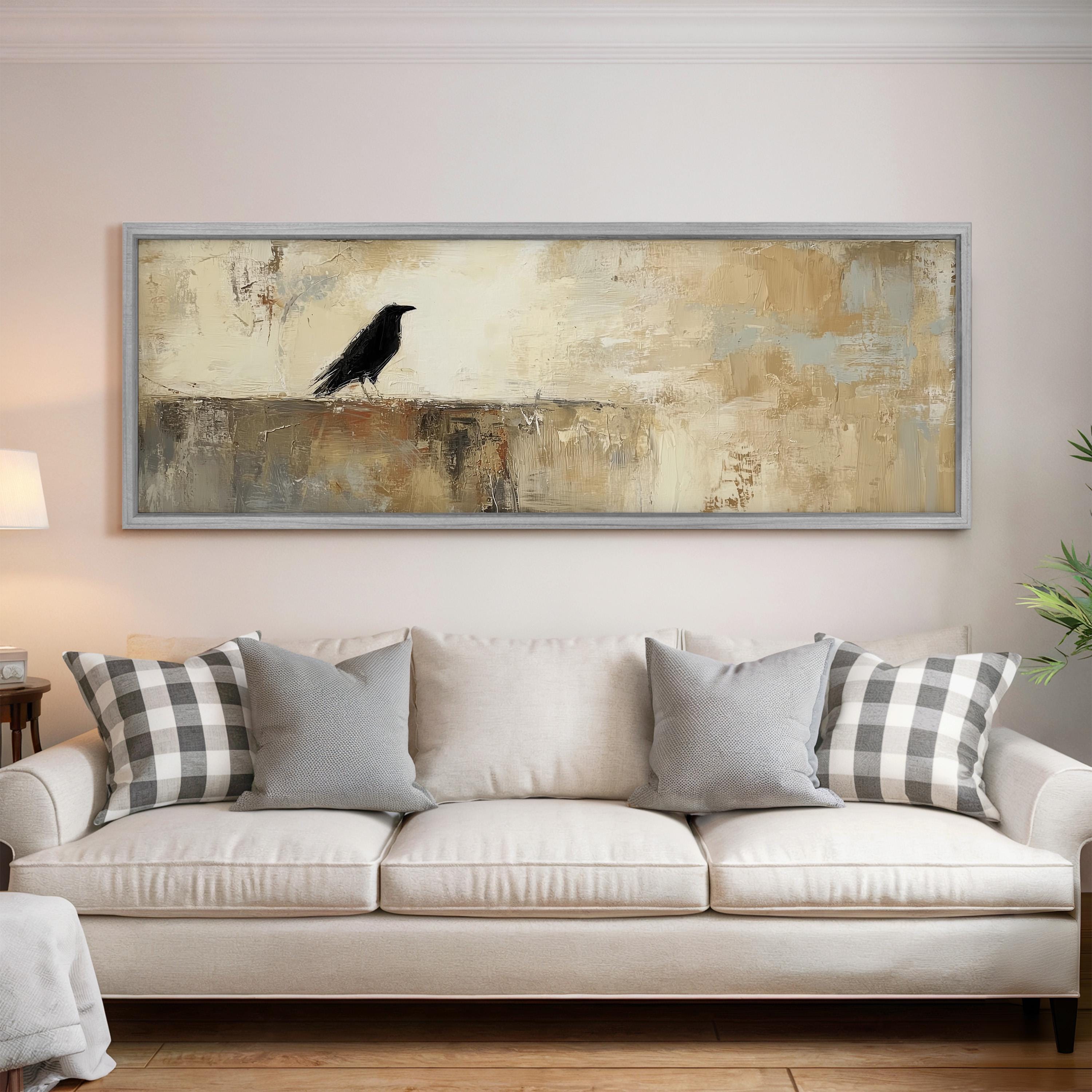 a large painting of a black bird perched on a wall above a white couch with gray and white plaid throw pillows.