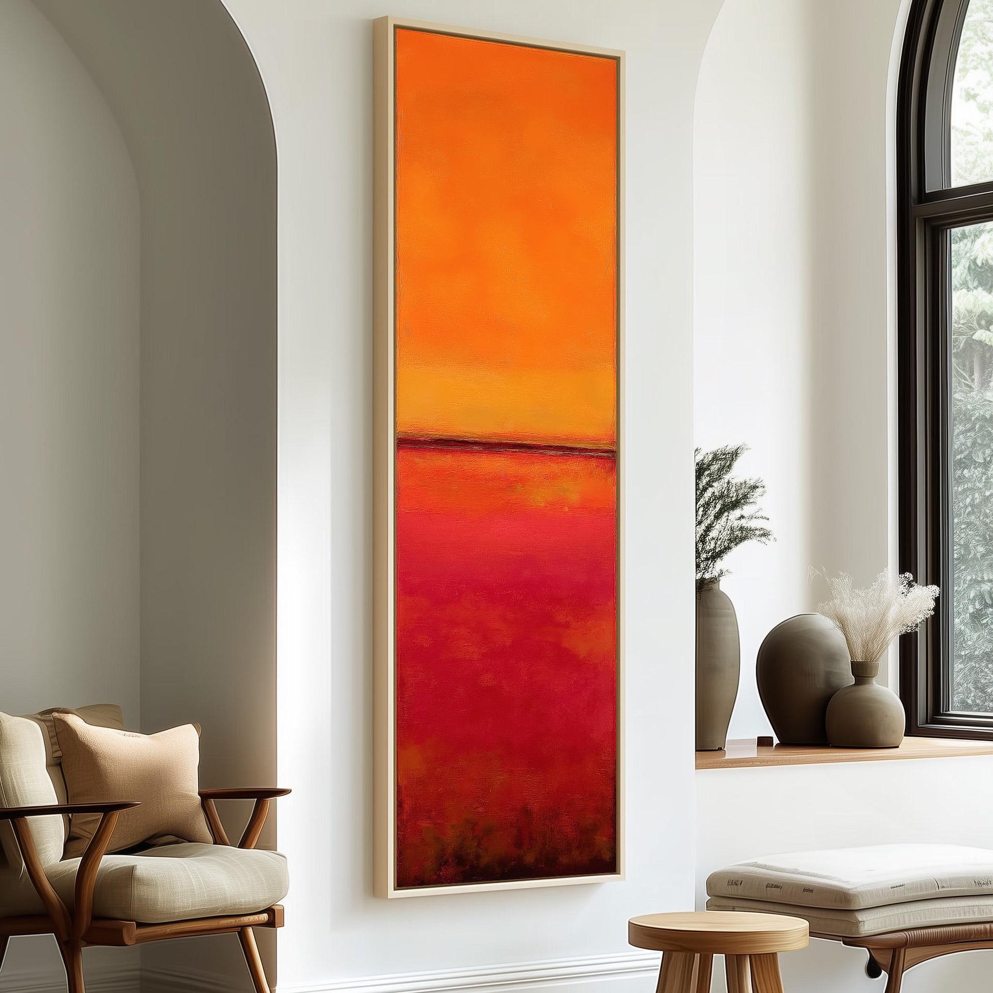 a modern living room with a large, vibrant abstract painting hanging on the wall. The painting has a striking red and orange color scheme, creating a warm and inviting atmosphere. The room is furnished with a beige armchair, a wooden side table, and a wooden stool, providing a comfortable and stylish seating area. The room also includes a window that allows natural light to enter, and a plant adds a touch of greenery to the space.