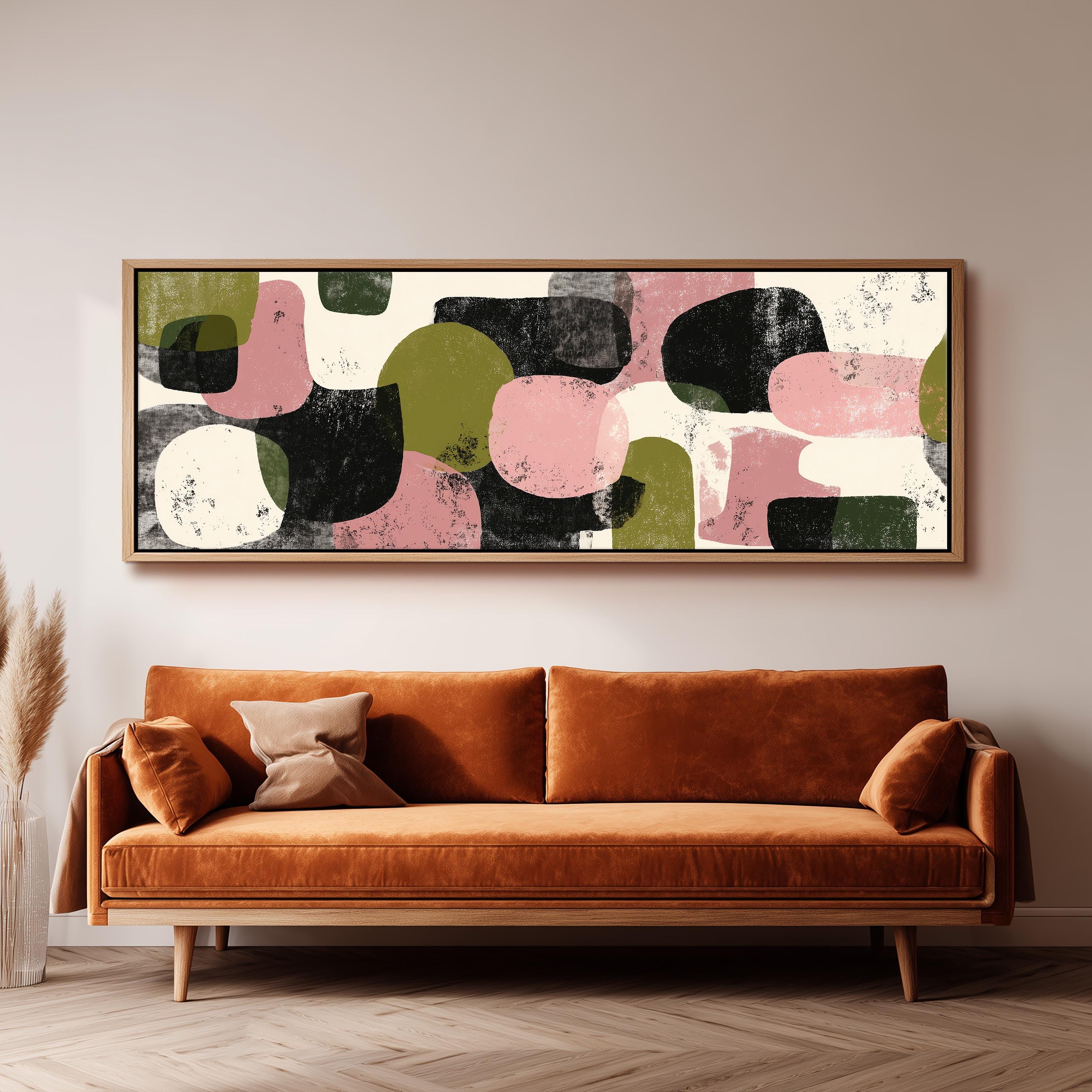 a large abstract painting hanging on a wall above a brown sofa with two pillows.