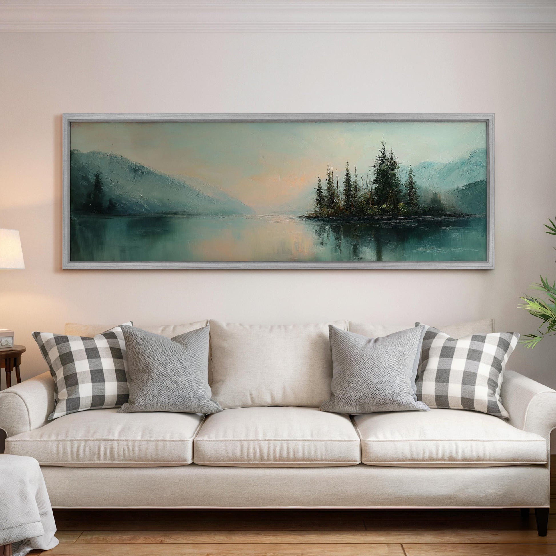 a large painting of a serene landscape hanging on a wall above a white sofa with gray and white patterned pillows.
