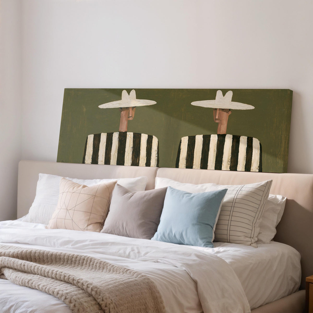 Two figures in striped shirts wide panoramic canvas print above a bed in a bedroom