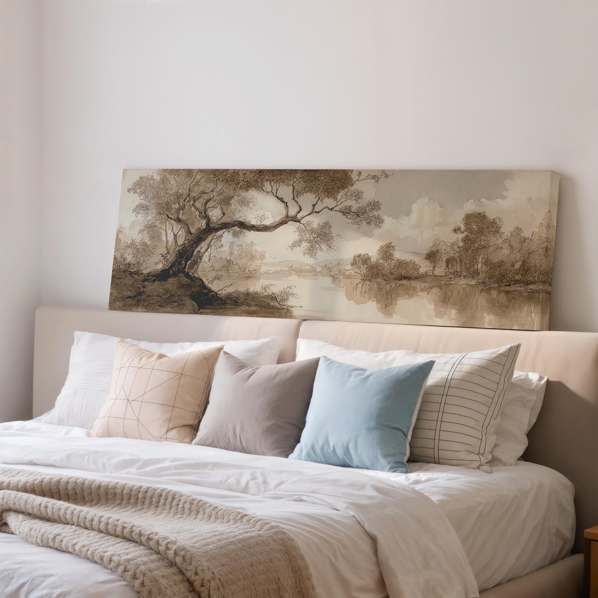 a large painting of a landscape hanging above a bed with white bedding and various pillows.