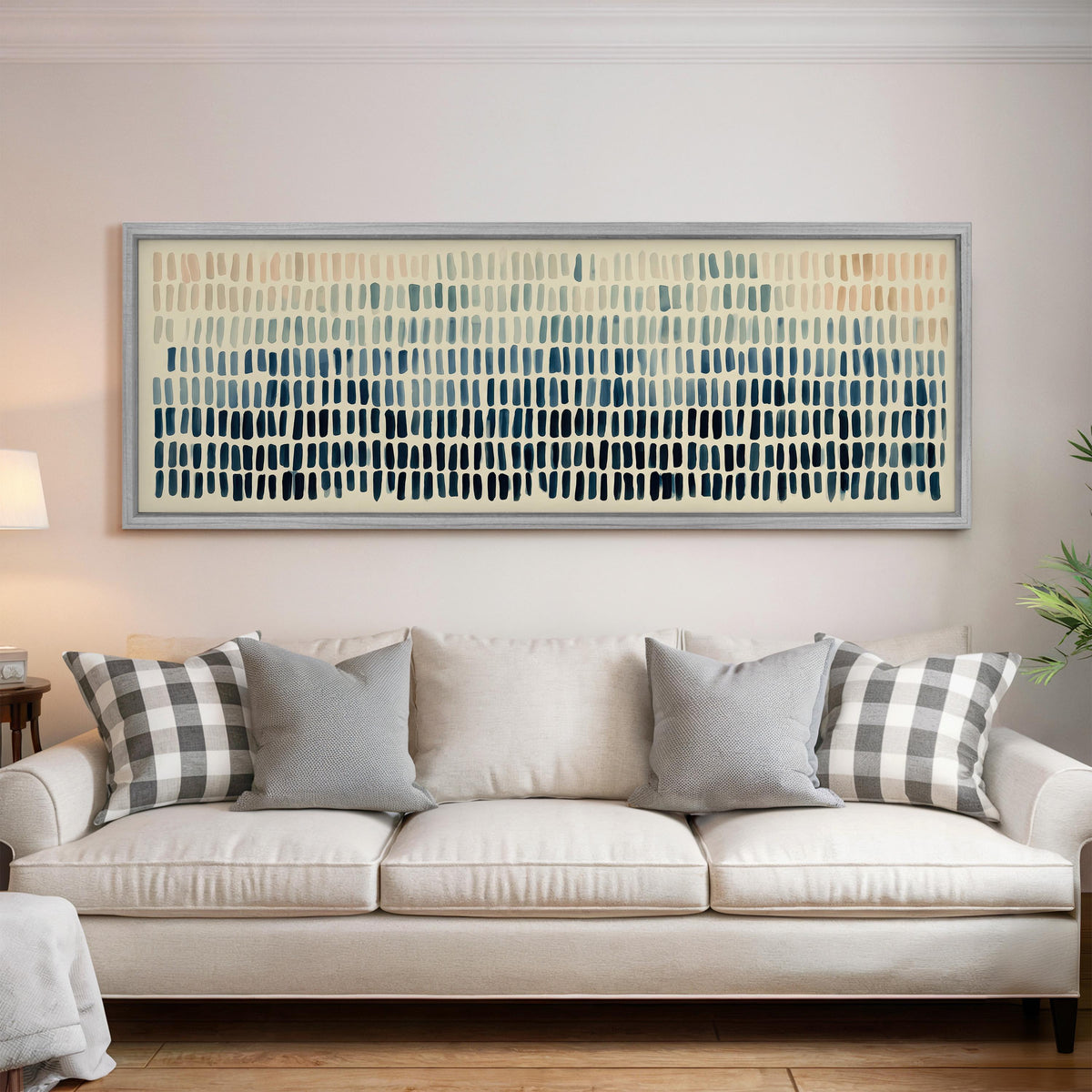 Brushmarks fading from peach to navy panoramic canvas print above a white sofa in a bright living room