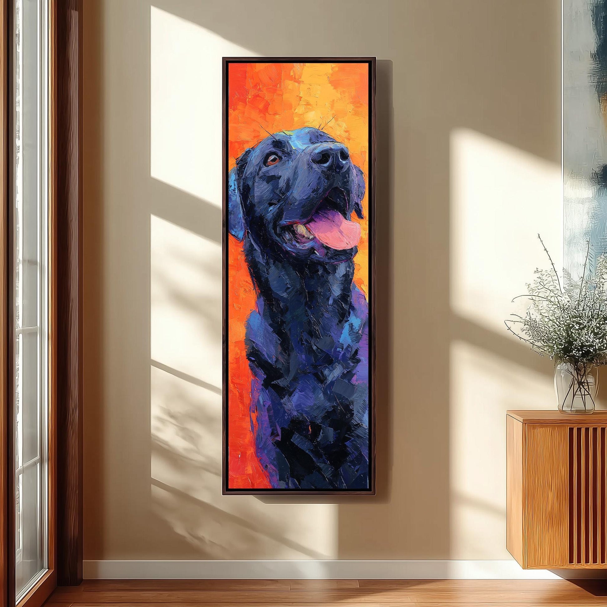 a large, colorful painting of a black dog with a pink tongue, hanging on a wall in a room with a wooden cabinet and a vase of flowers.