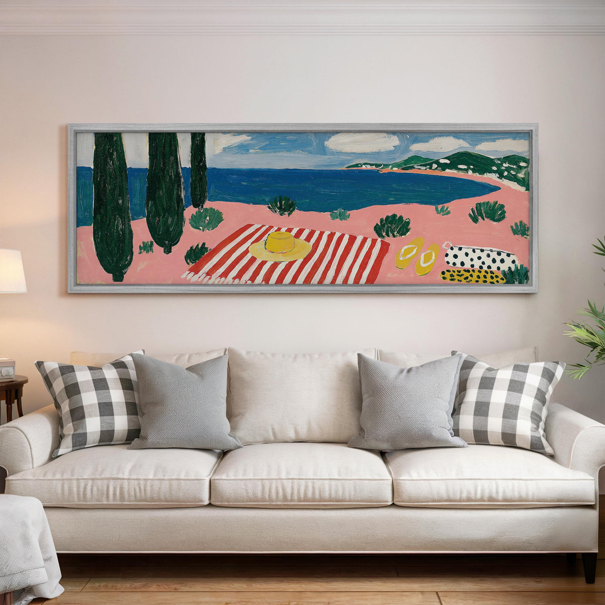 Mediterranean beach day with a striped towel panoramic canvas print above a white sofa in a bright living room