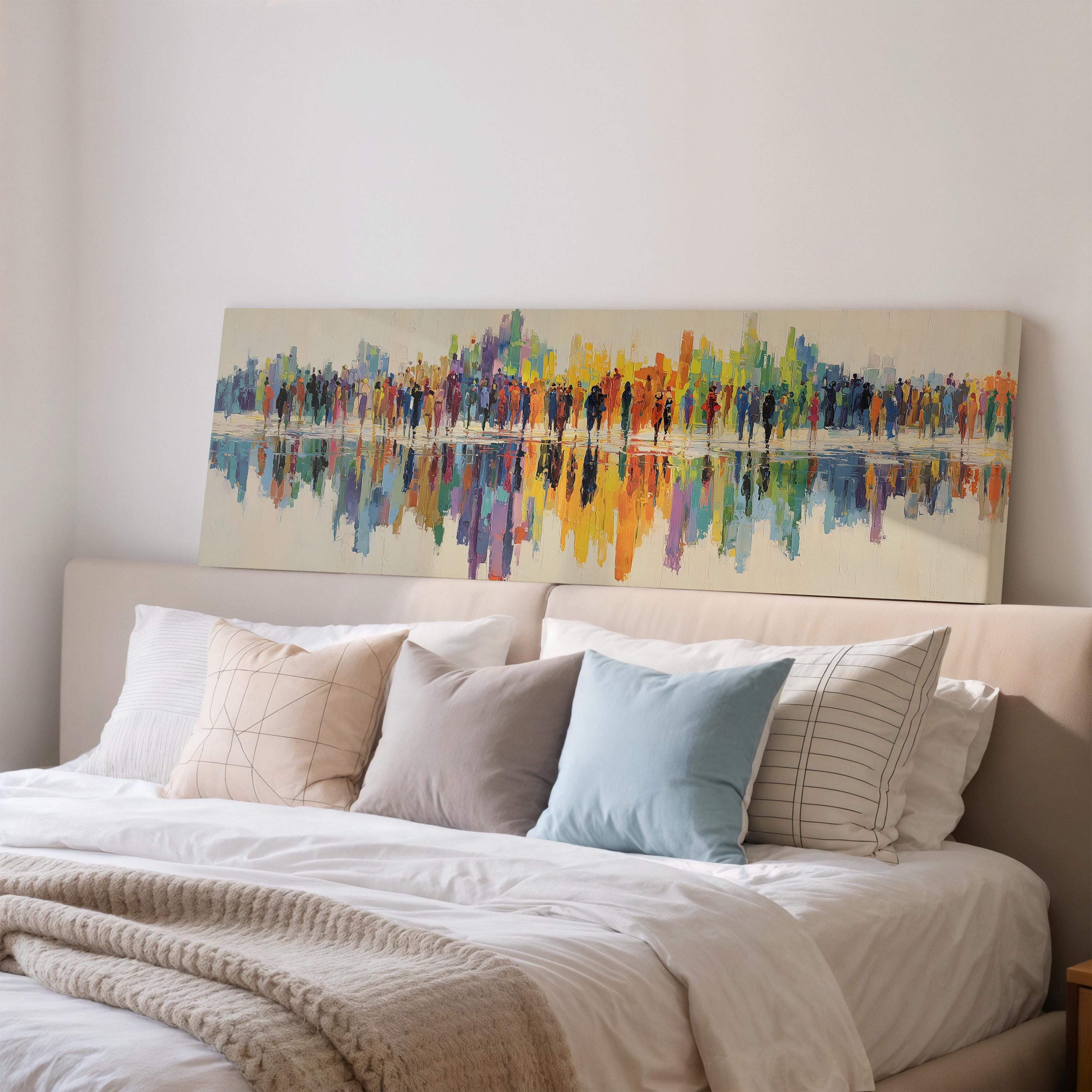 a large, colorful painting of a cityscape hanging on a wall above a bed with white bedding and pillows.