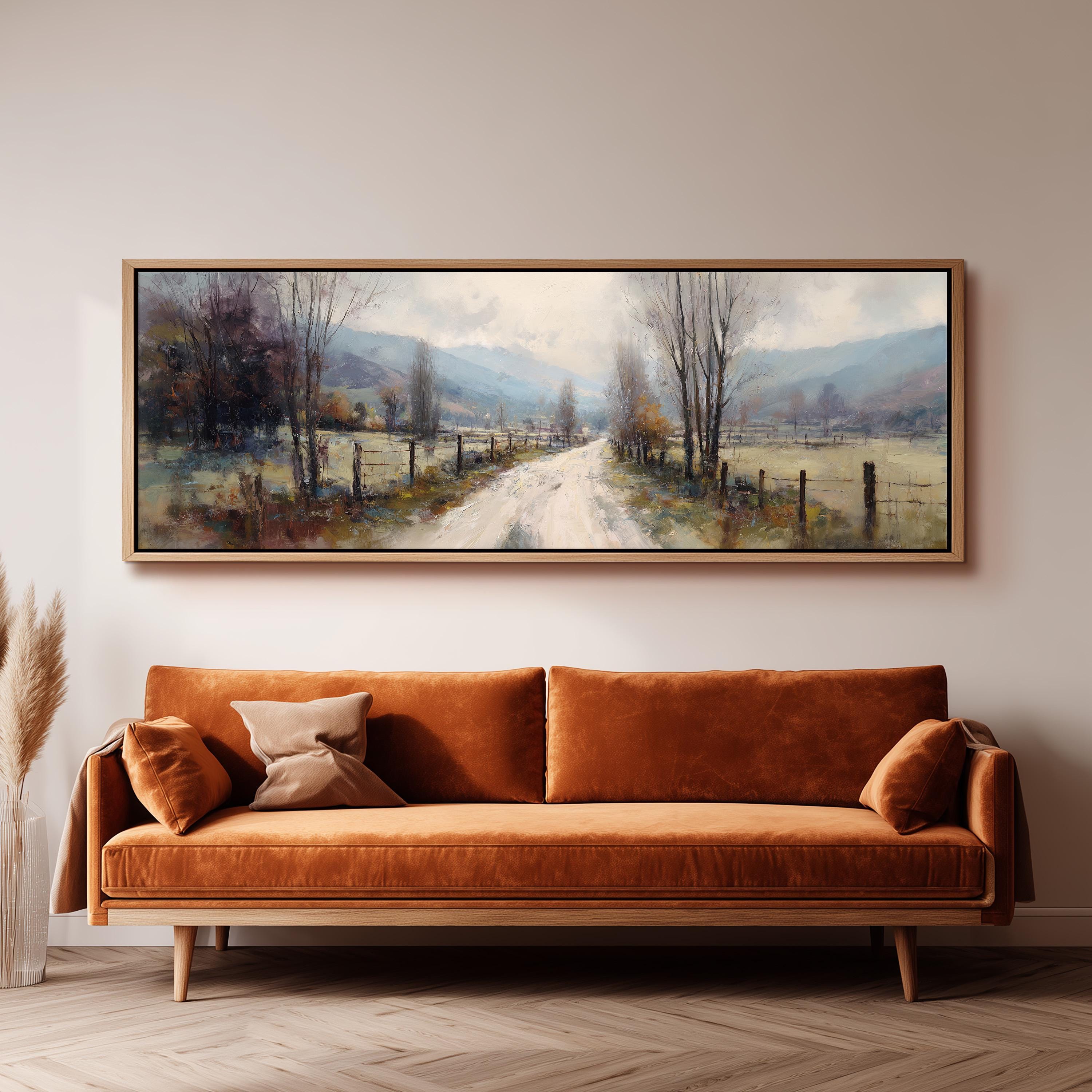a large, rectangular painting hanging on a wall above a brown sofa.