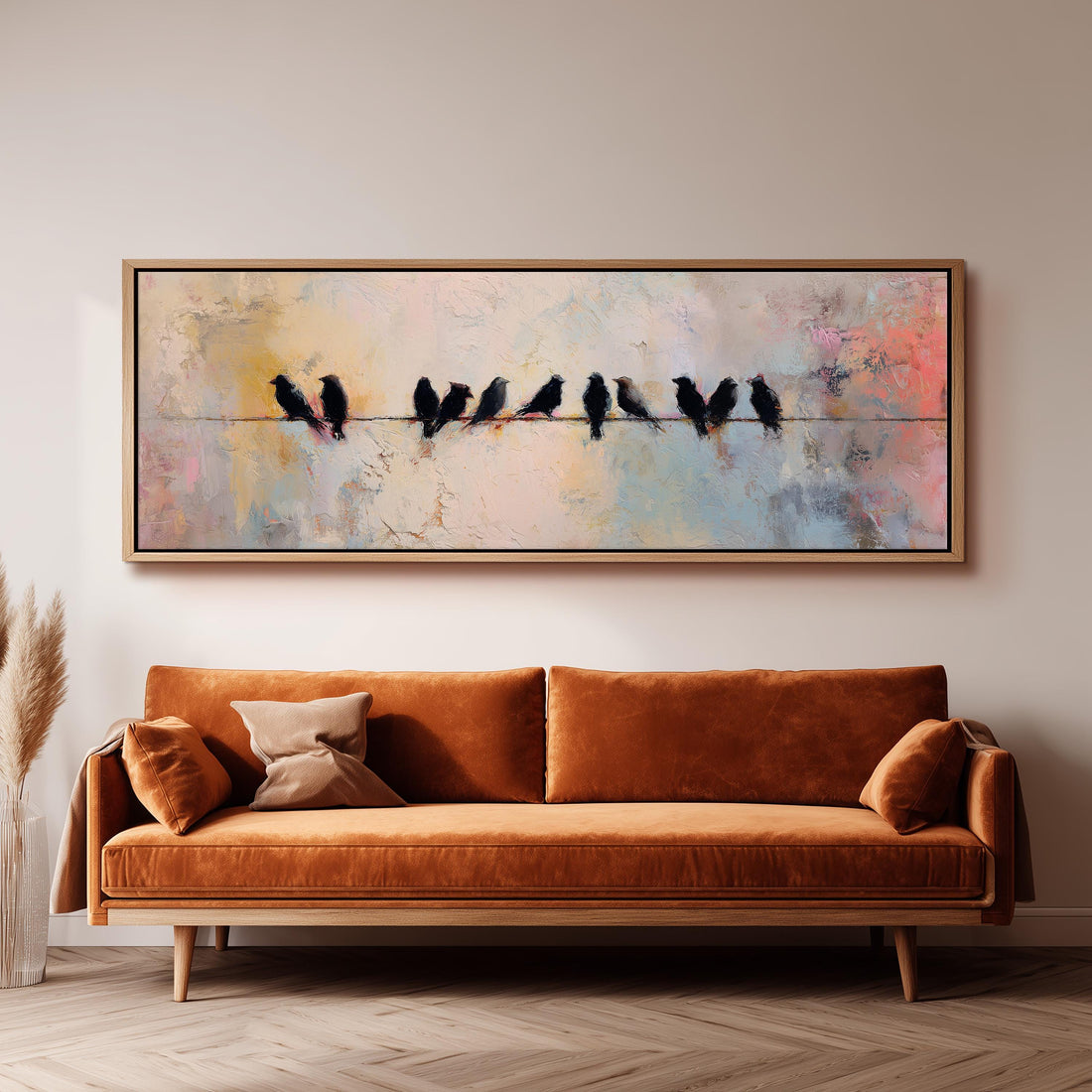 a large painting of birds perched on a wire, hanging on a wall above a brown sofa.