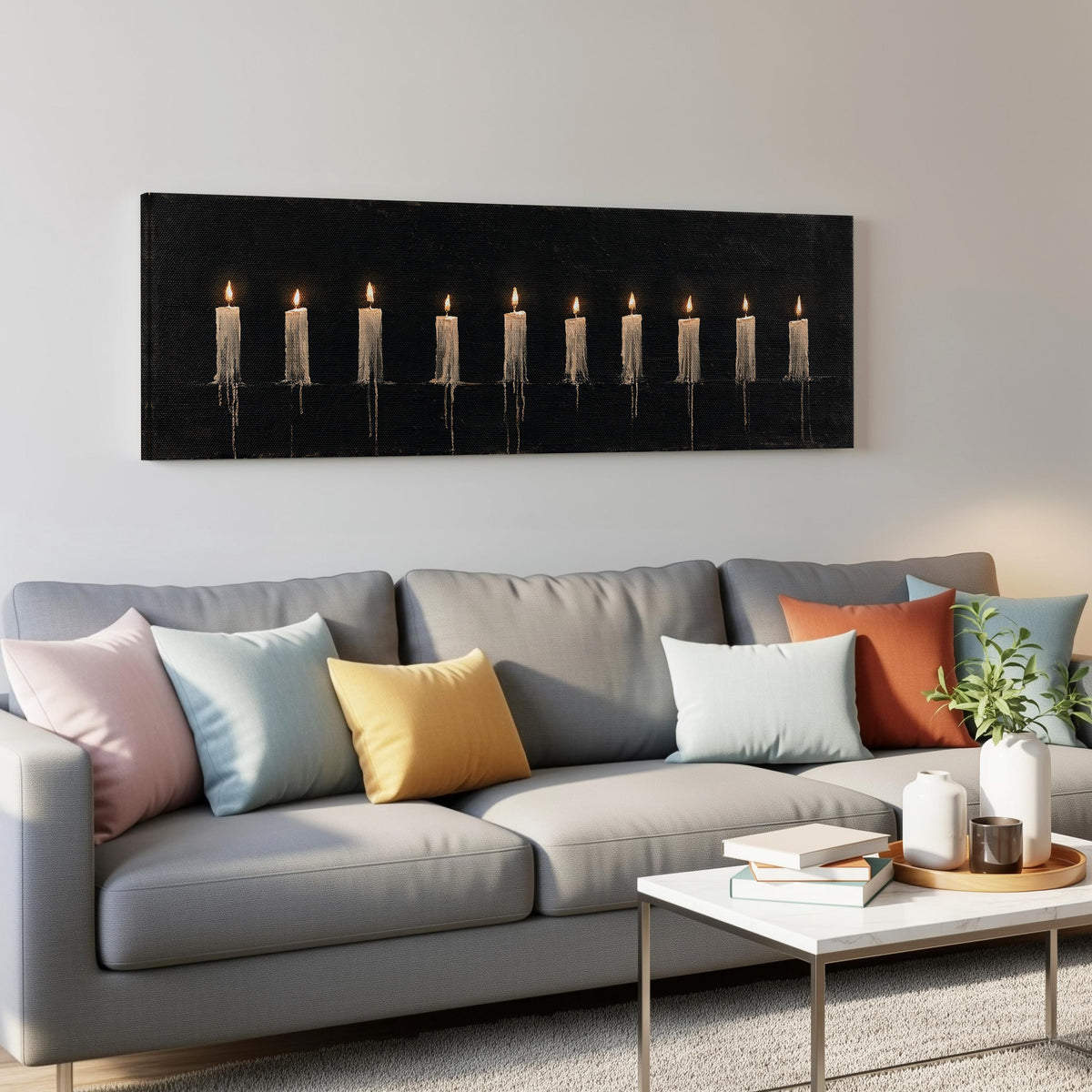Ten lit candles on black panoramic canvas print above a grey sofa in a living room