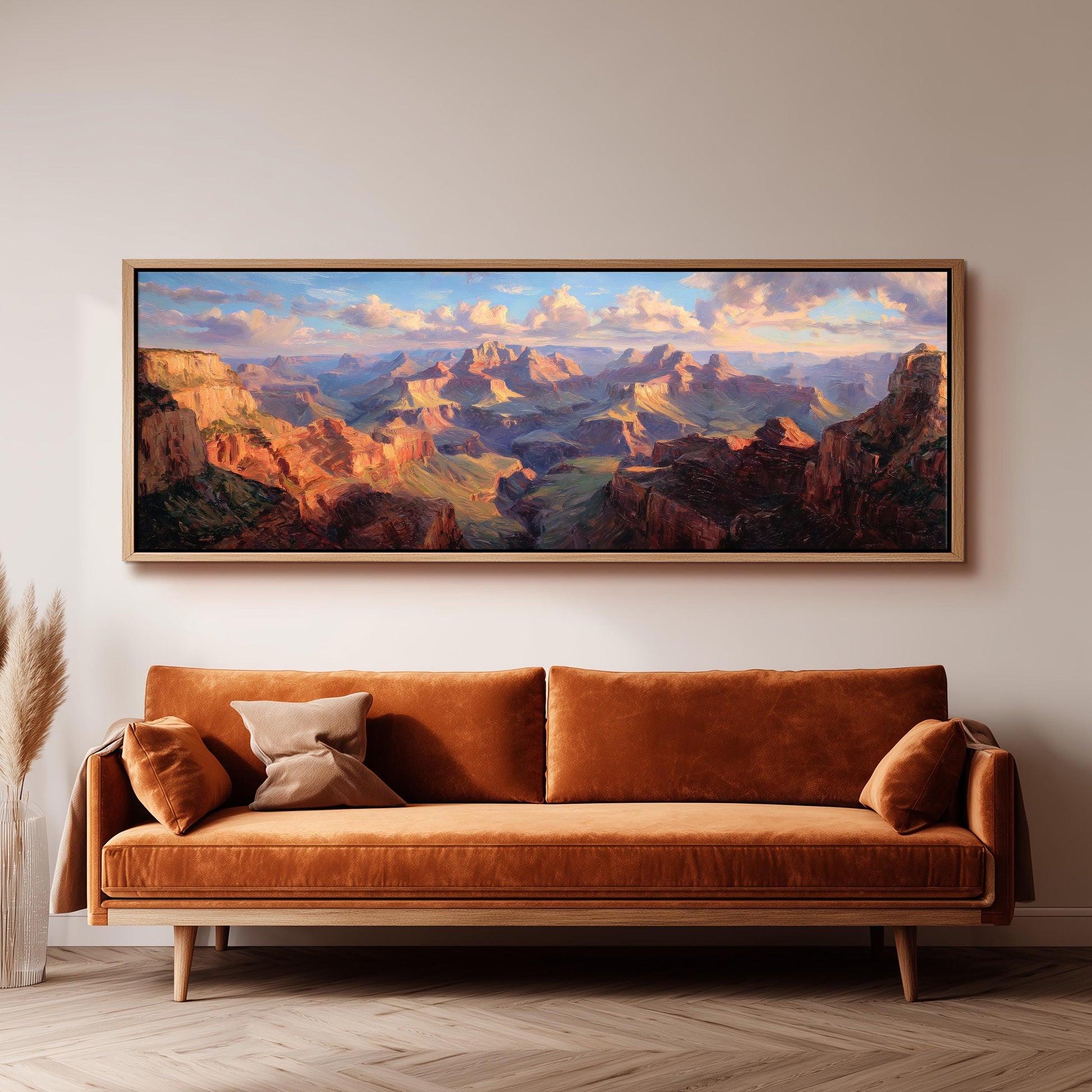 a large, framed painting of a mountainous landscape hanging on a wall above a brown sofa.