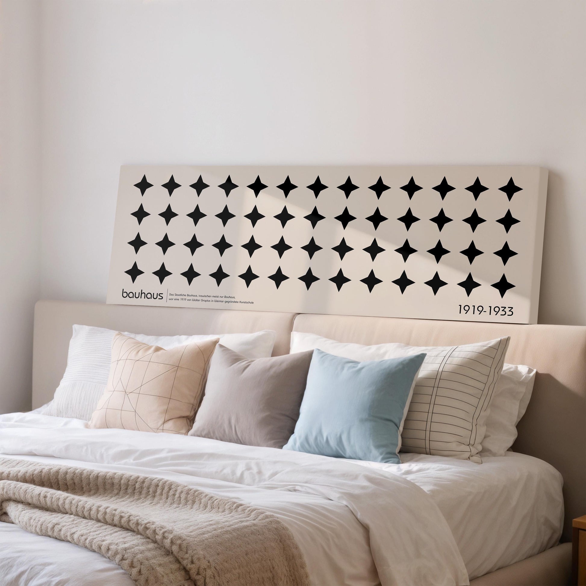 a large bed with a white headboard and a black and white geometric pattern on the headboard.