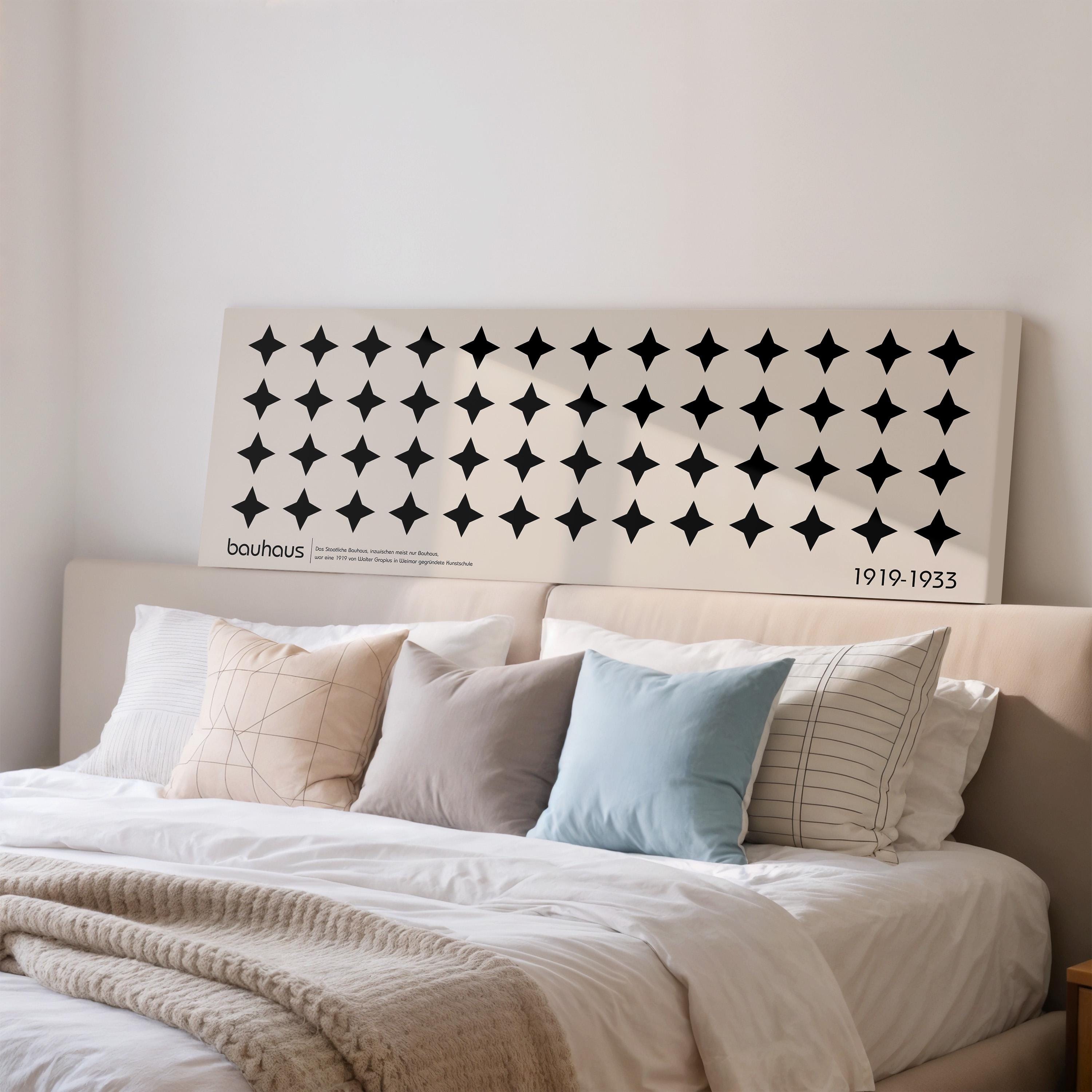 a large bed with a white headboard and a black and white geometric pattern on the headboard.