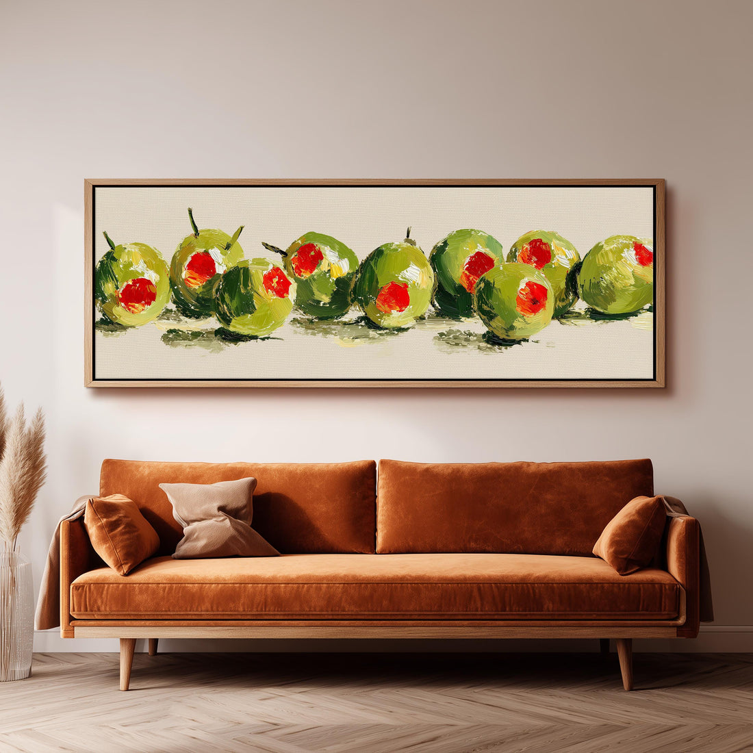 a dining room with a wooden table and four chairs. Above the table, there is a large painting of green olives with red centers. The painting is framed and hangs on the wall. The table is set with a bowl of fruit and a vase of flowers, creating a welcoming and inviting atmosphere.
