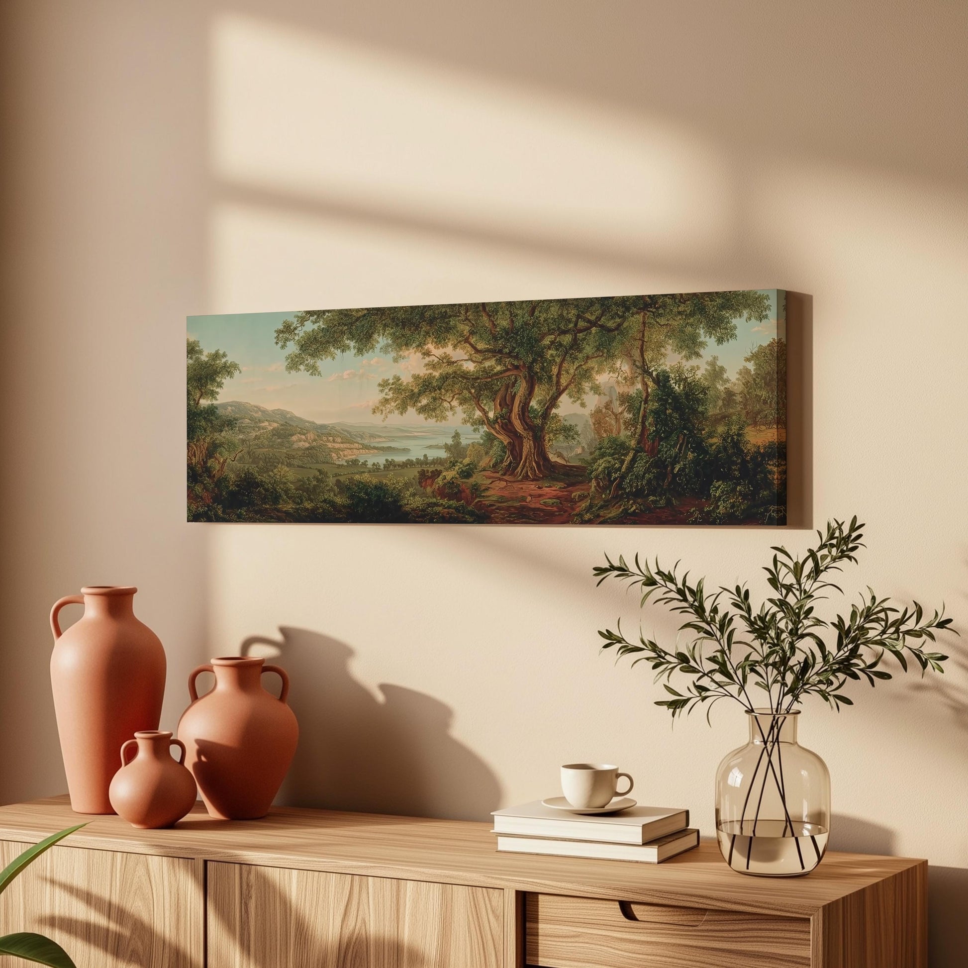 a wooden cabinet with a painting of a forest scene hanging on the wall above it. The cabinet also has three orange vases and a glass vase with greenery on top of it.