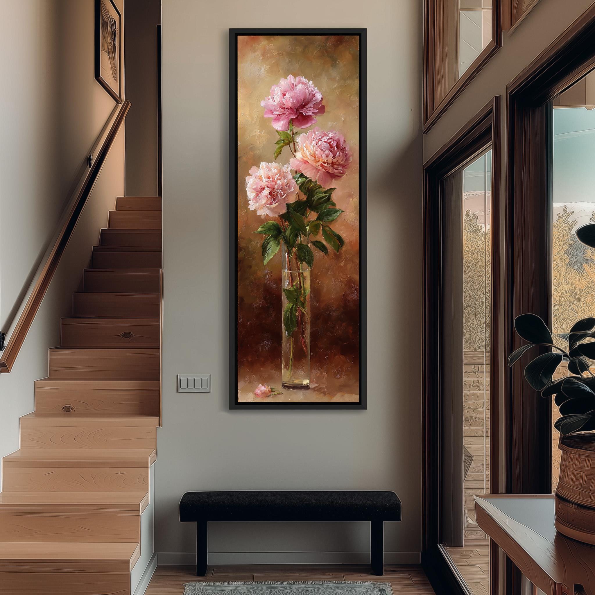 a large painting of pink flowers hanging on the wall, with a vase containing the flowers placed on a table in the foreground.
