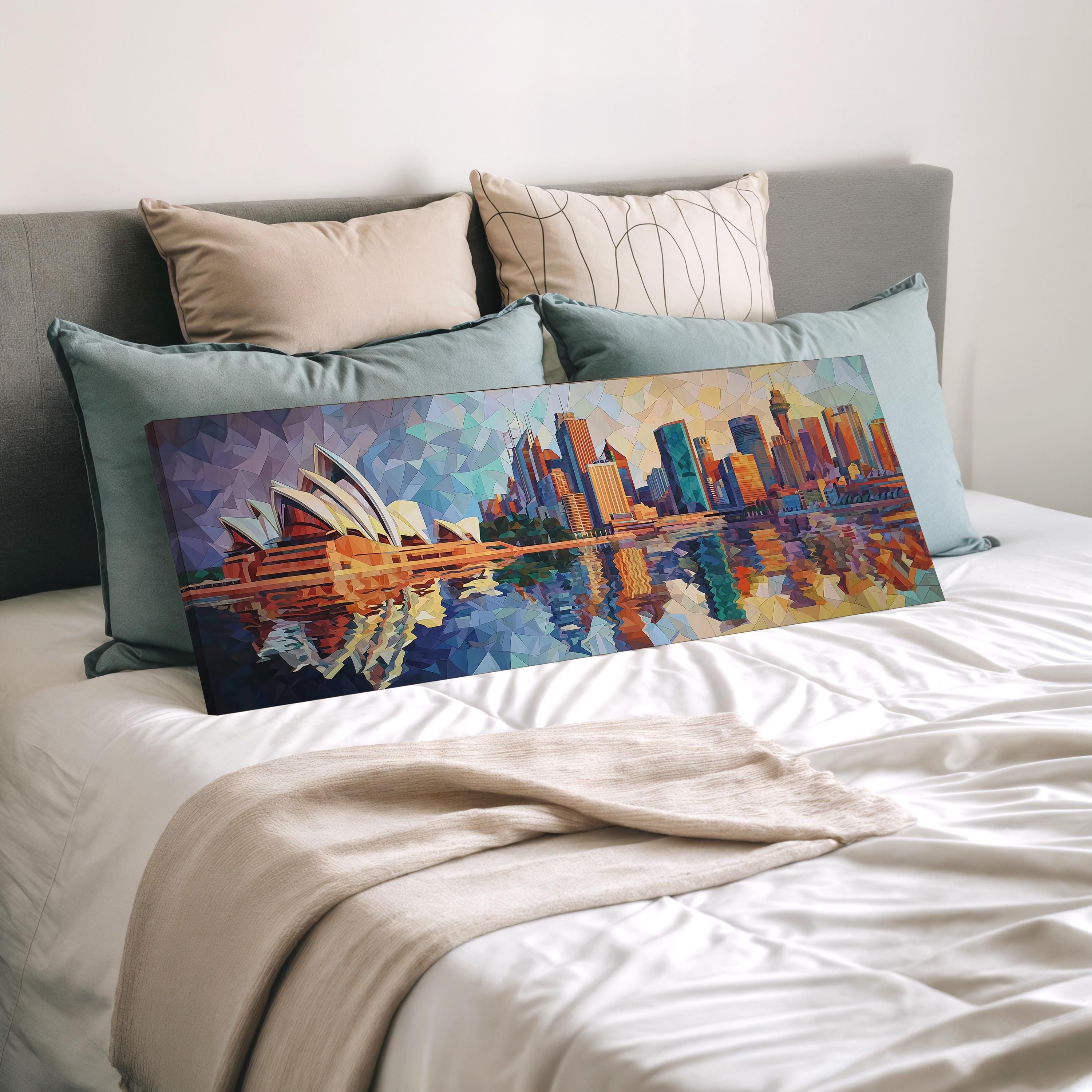 a large, colorful painting of the Sydney Opera House displayed on a bed, surrounded by pillows.