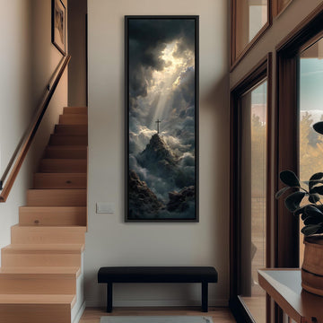 a large, framed painting of a mountain landscape with a cross on top, hanging on a wall in a hallway.
