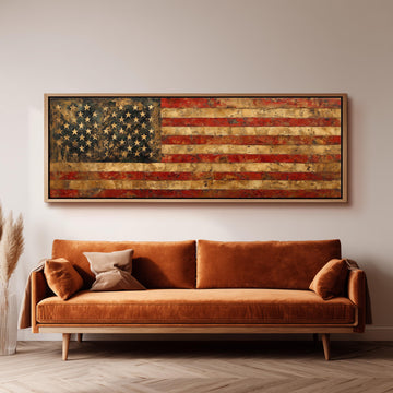 a large, old American flag painted on the wall above a brown sofa with two pillows.