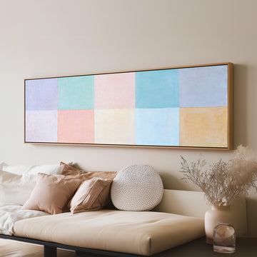 Pastel checkerboard grid long horizontal canvas print above a sofa in a living room